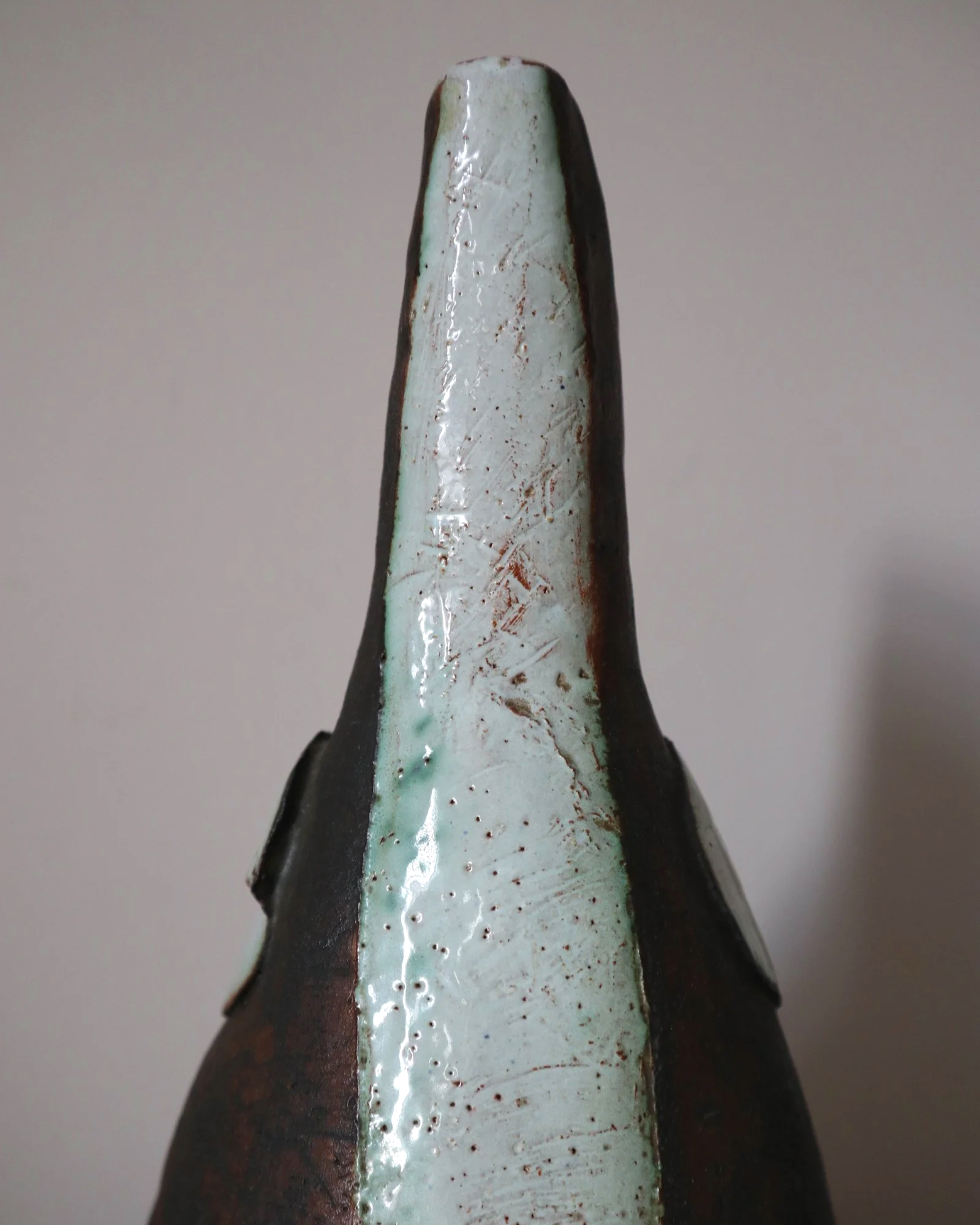 Vintage hand-built ceramic Brutalist art vase, featuring an abstract, asymmetrical design with textured white, dark brown, and subtle green glazes.
