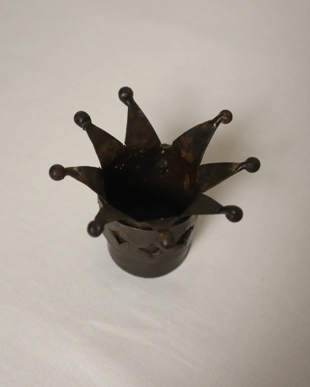 Pair of Modernist style, small dark metal jester hat or crown shaped tea light holders with diamond cut outs.