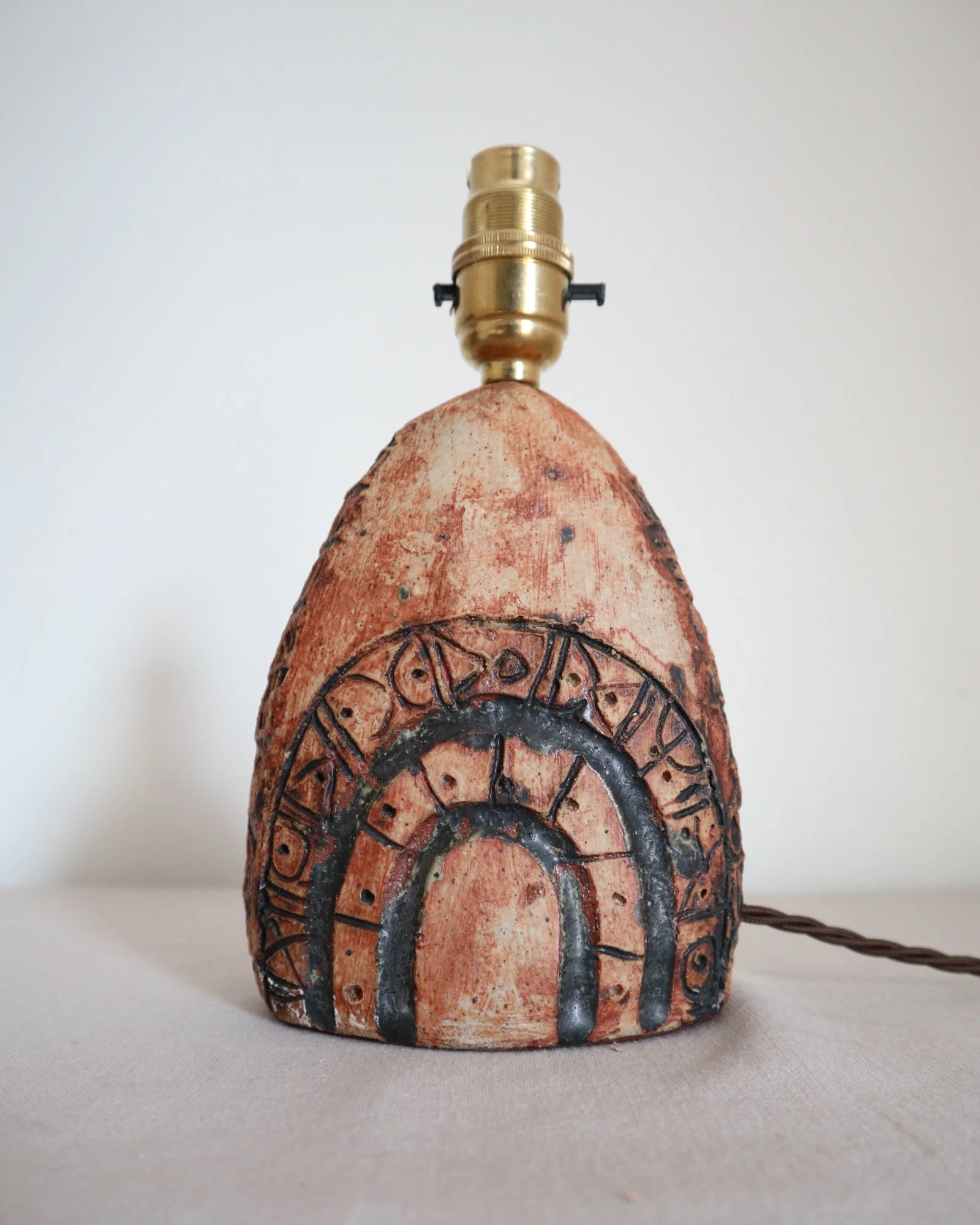 Small Brutalist stoneware table lamp by British potter Bernard Rooke. With stamped, rune-like impressions. Circa 1970s.