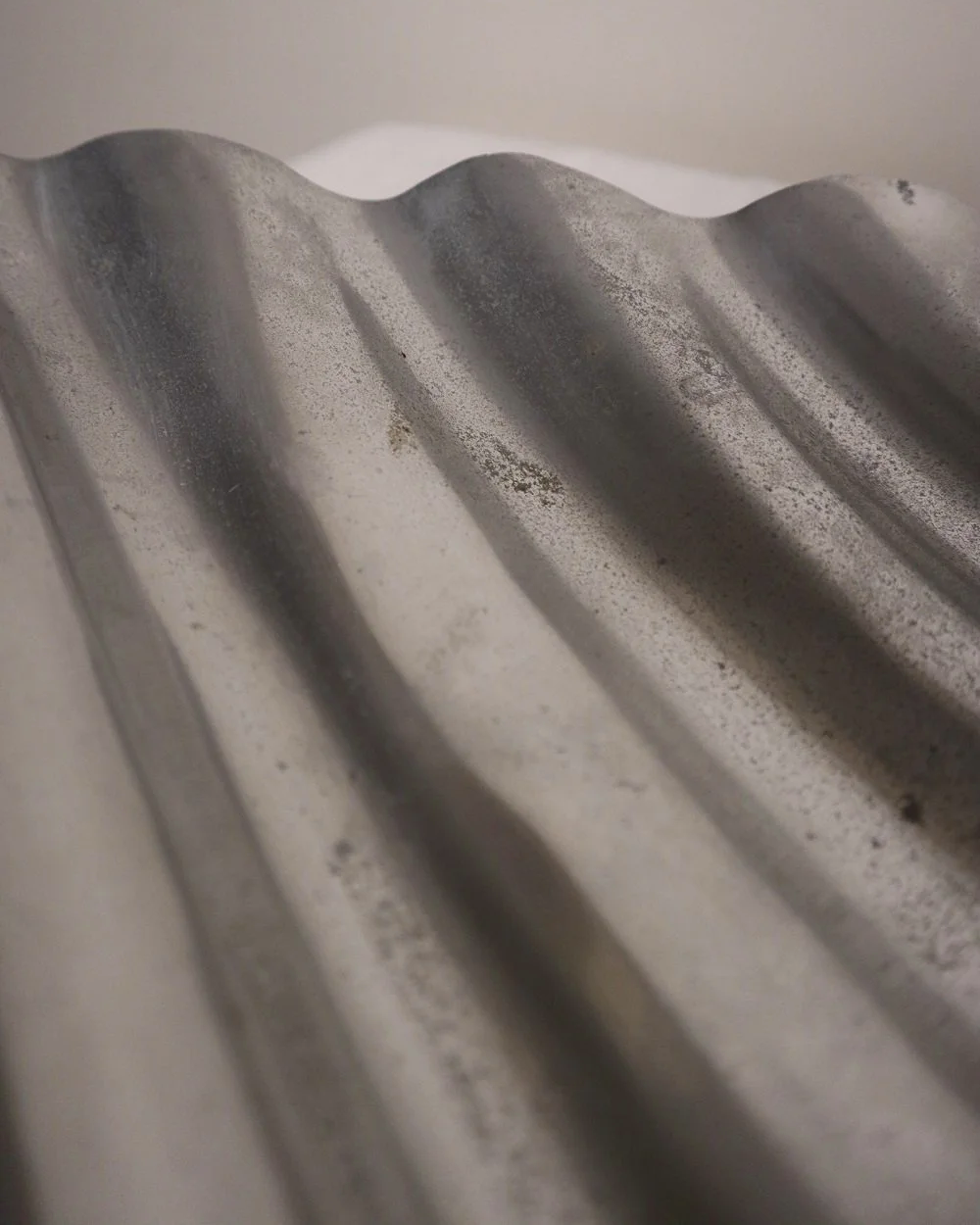 Large mid century, shiny cast aluminium triangular display dish with wavy edge.