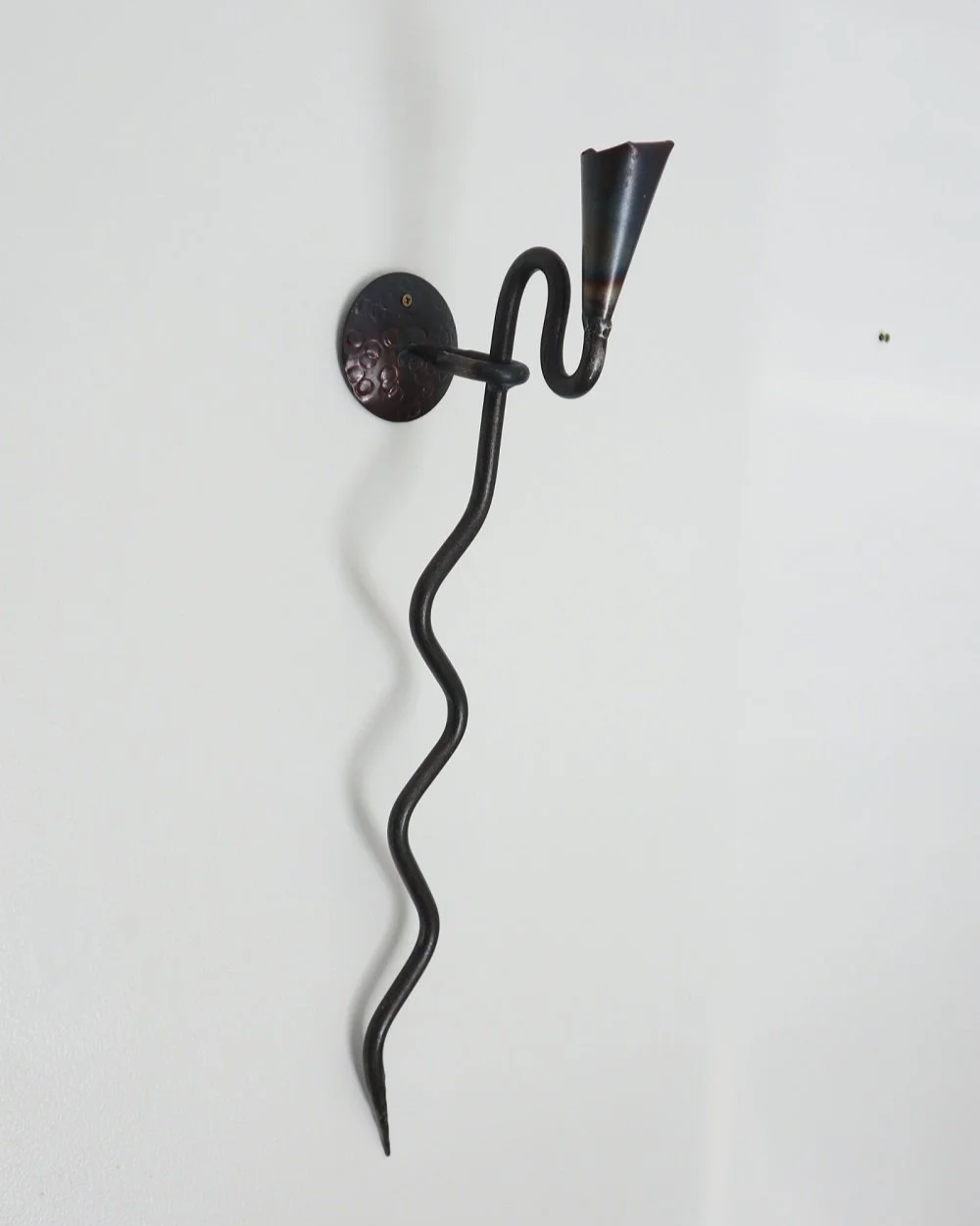 Large Swedish black iron wall sconce candleholder with wavy design. Circa 1960s.