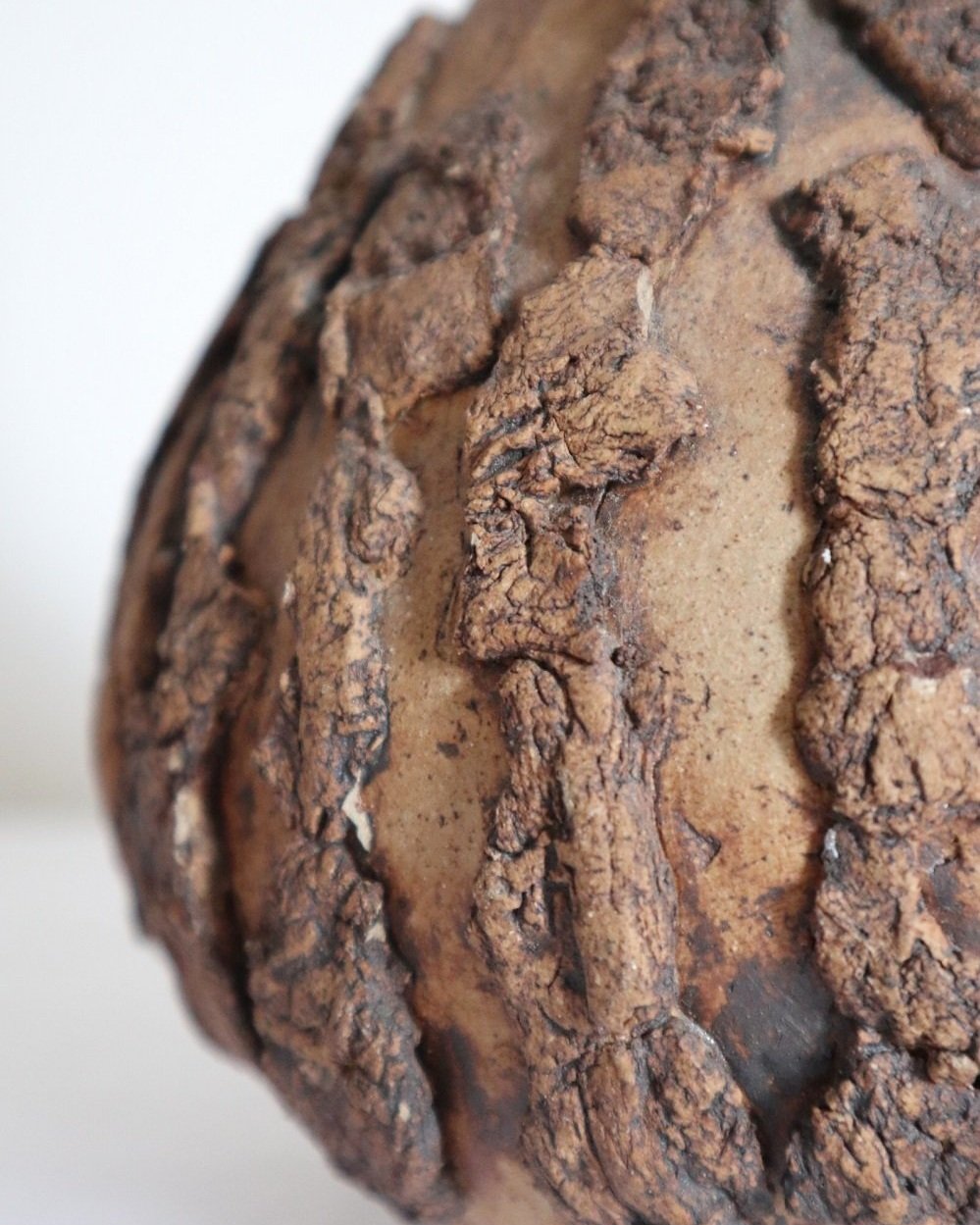 Studio pottery brown ceramic decorative vase with textured, tree bark effect decorations and a tapered neck. Age unknown.