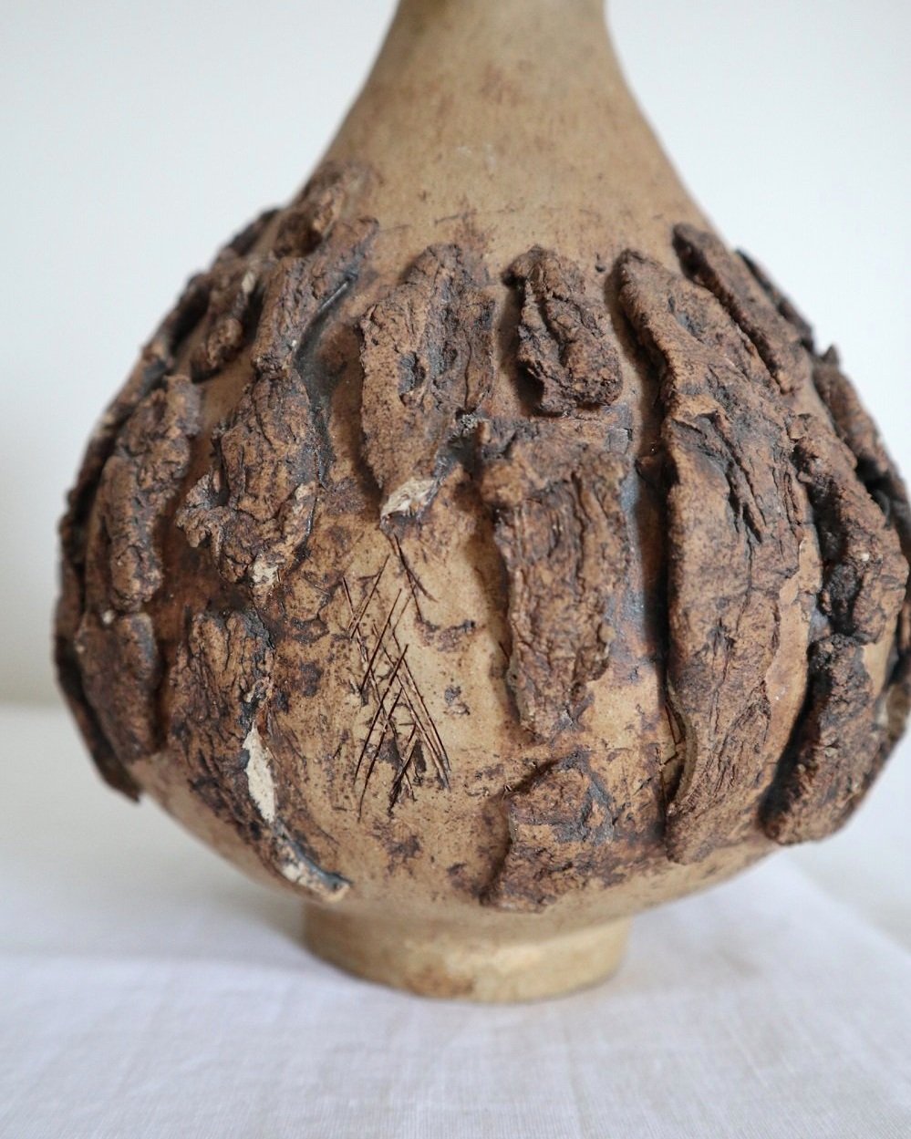 Studio pottery brown ceramic decorative vase with textured, tree bark effect decorations and a tapered neck. Age unknown.