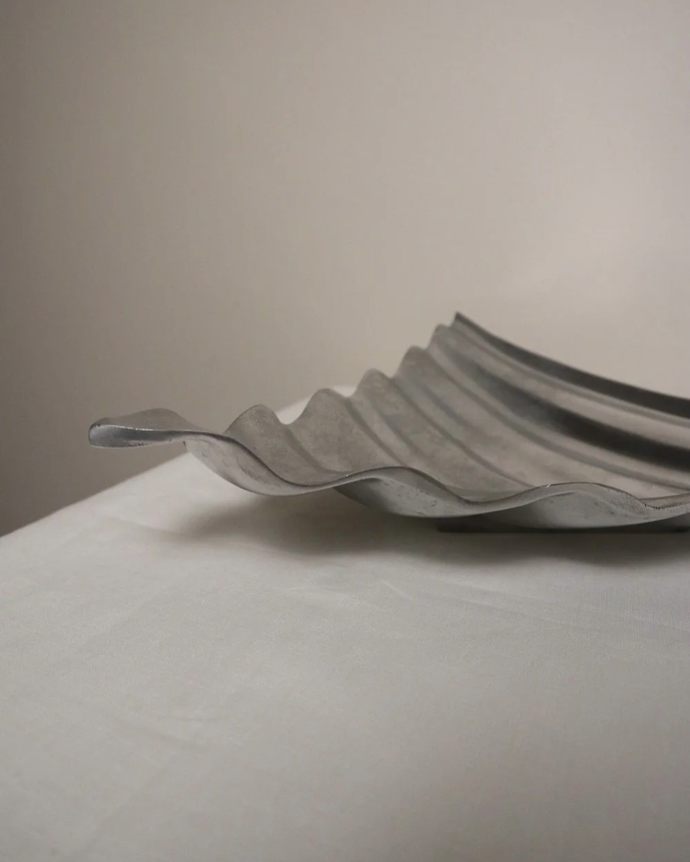 Large mid century, shiny castaluminium triangular display dish with wavy edge.