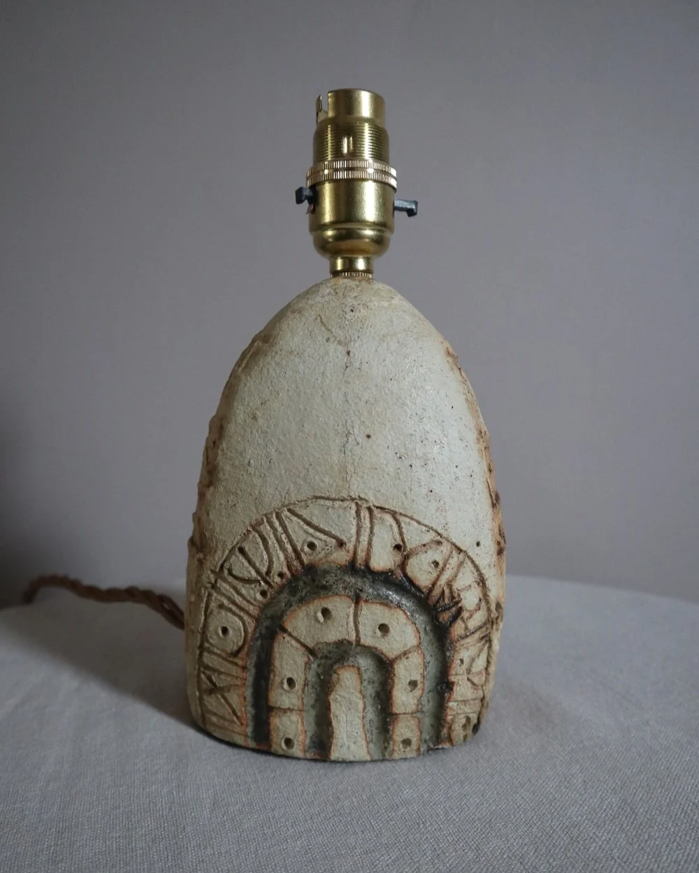 Small Brutalist stoneware table lamp by British potter Bernard Rooke. With stamped, rune-like impressions. Circa 1970s.