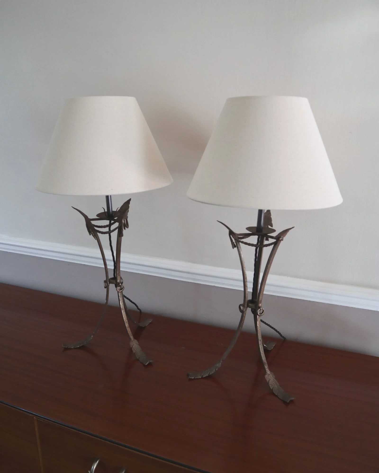 Pair of French style mid century metal tripod table lamps featuring three arrows.