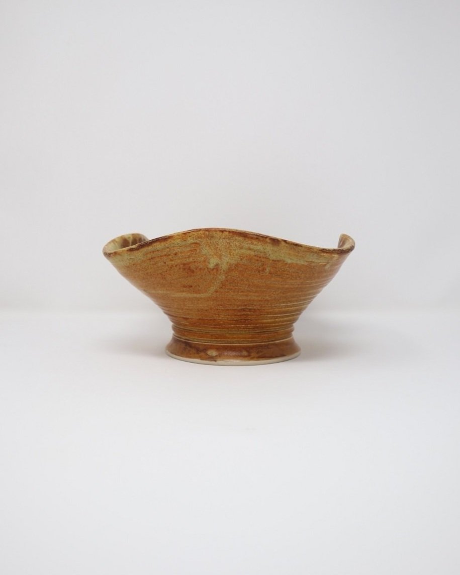 tage, handmade studio pottery ceramic bowl with wavy edge and brown, orange and ochre glaze. Marked Baughan 1997 to base.