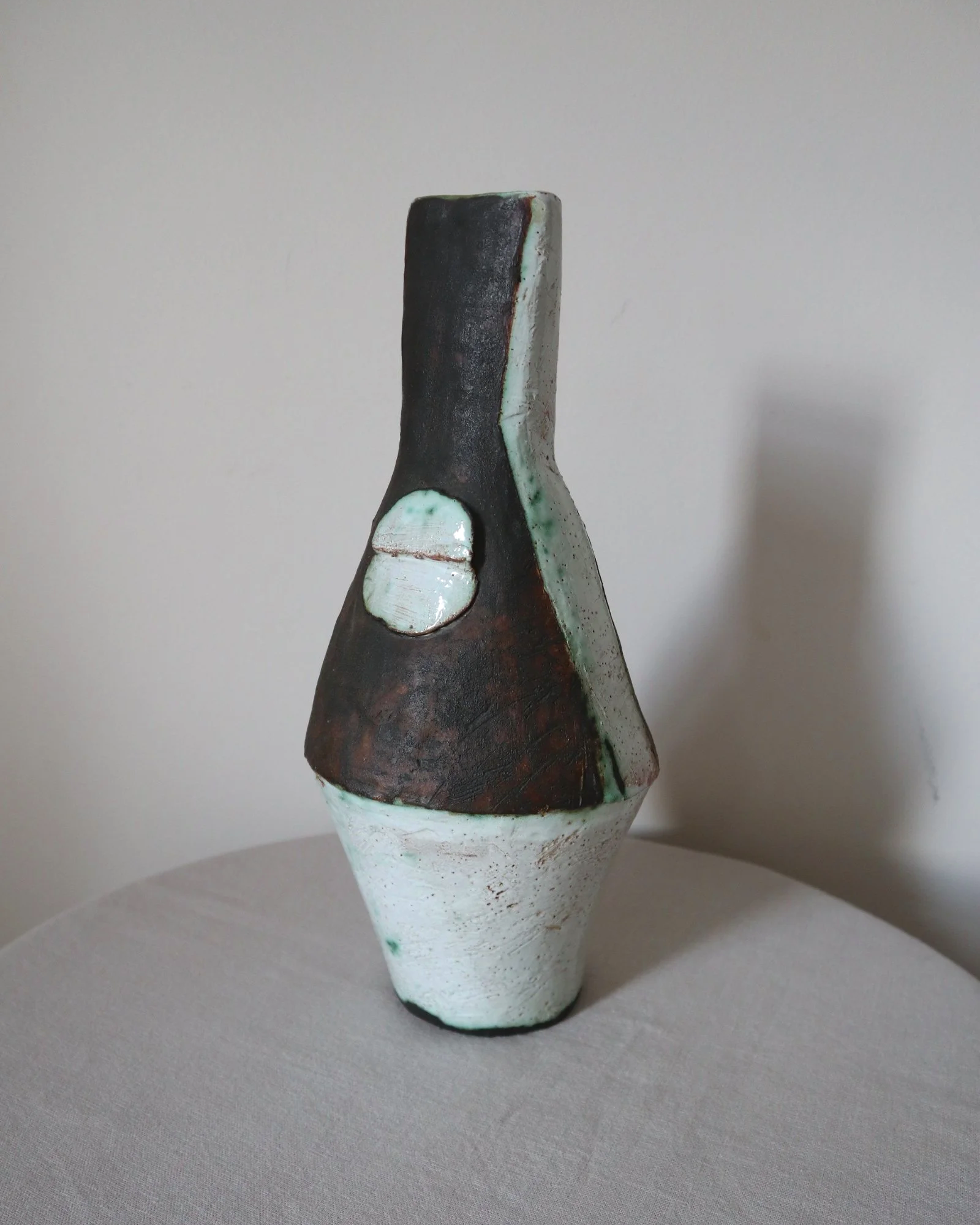 Vintage hand-built ceramic Brutalist art vase, featuring an abstract, asymmetrical design with textured white, dark brown, and subtle green glazes.