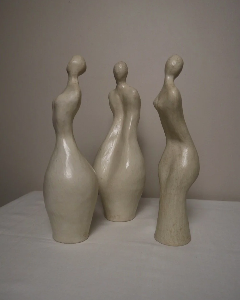 Set of three white ceramic abstract sculptures in the shape of the female form. Unknown age.  Signed 'R W Art / RoseWood Art'