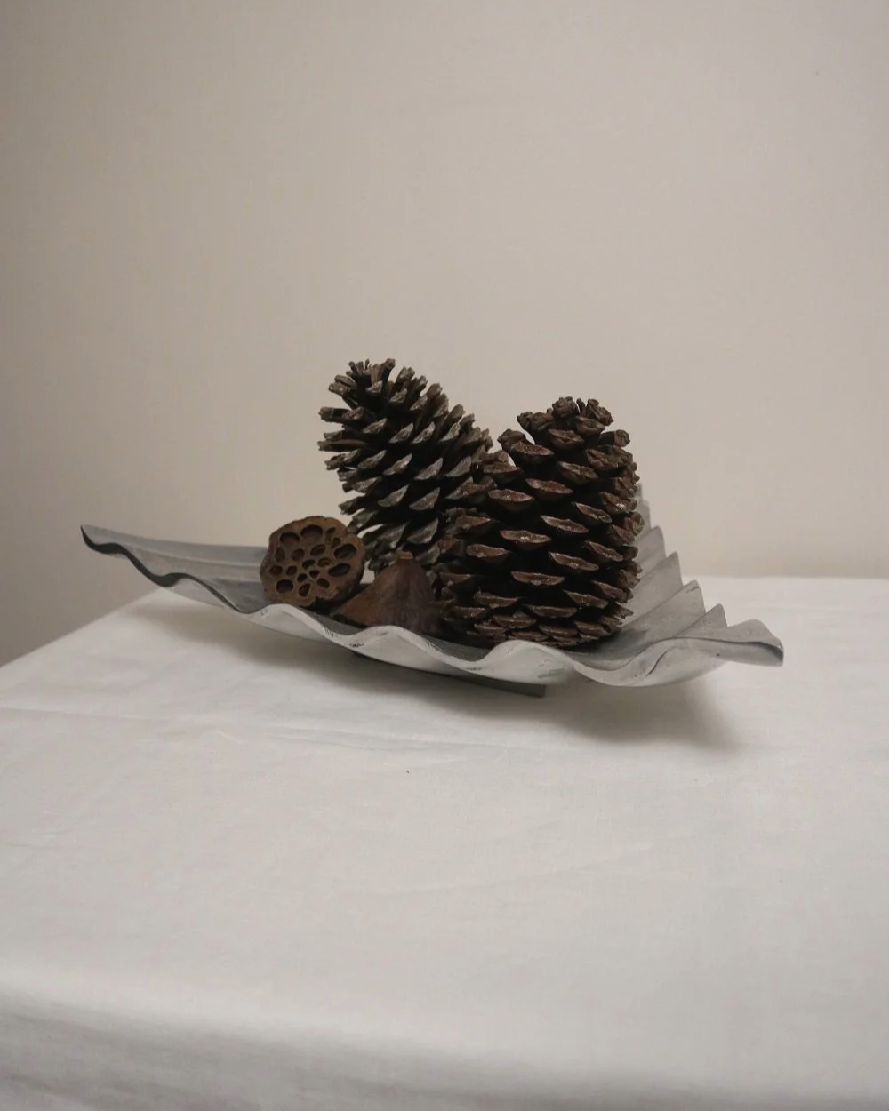 Large mid century, shiny cast aluminium triangular display dish with wavy edge.