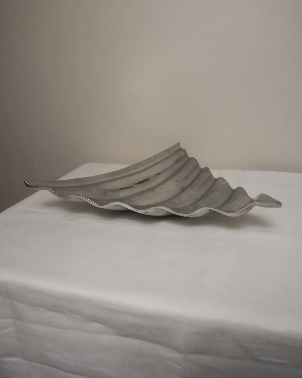 Large mid century, shiny cast aluminium triangular display dish with wavy edge.