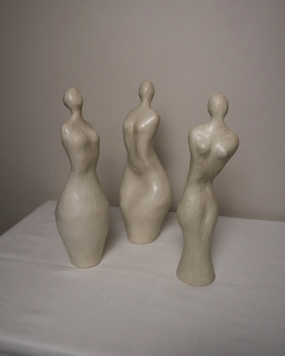 Set of three white ceramic abstract sculptures in the shape of the female form. Unknown age.  Signed 'R W Art / RoseWood Art'