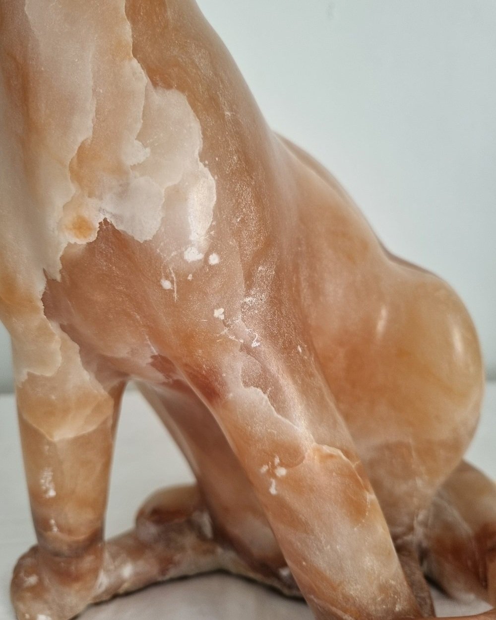 Vintage, heavy hand carved soft pink alabaster cat with striking natural grain and smooth lines.