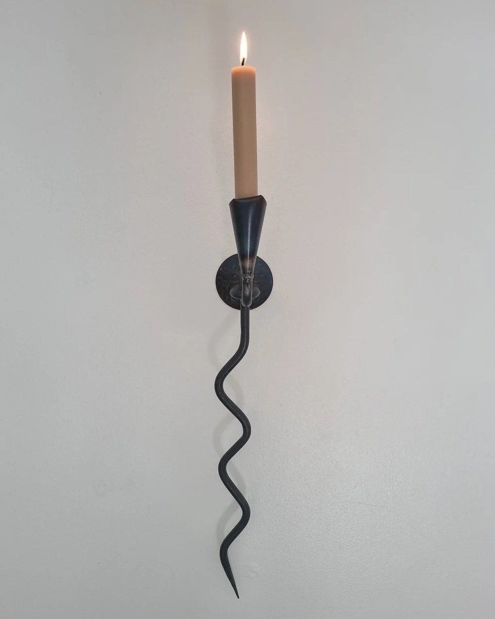 Large Swedish black iron wall sconce candleholder with wavy design. Circa 1960s.