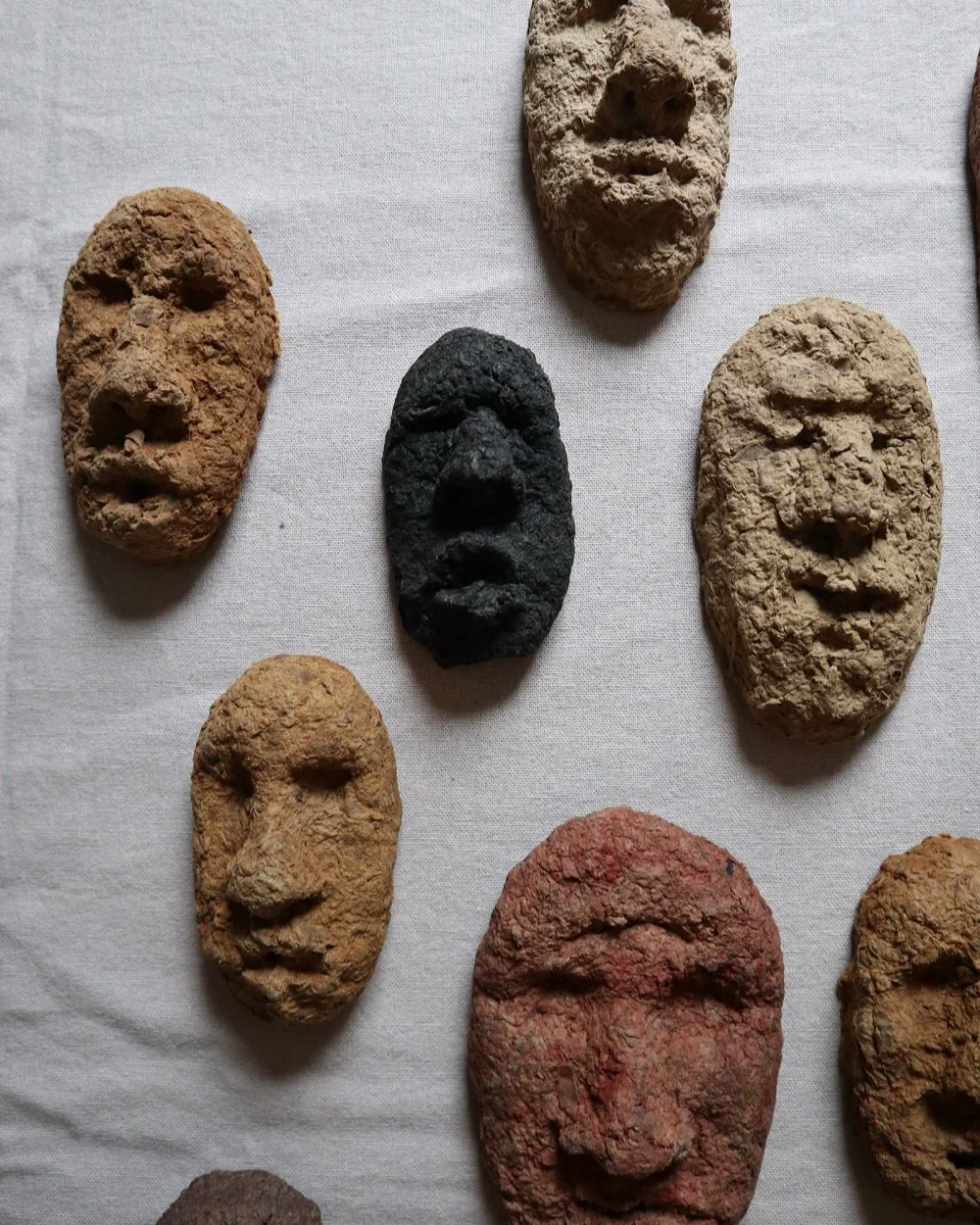 Set of unique handmade textured papier mache faces in earthy tones. Unknown age.  Unknown artist.