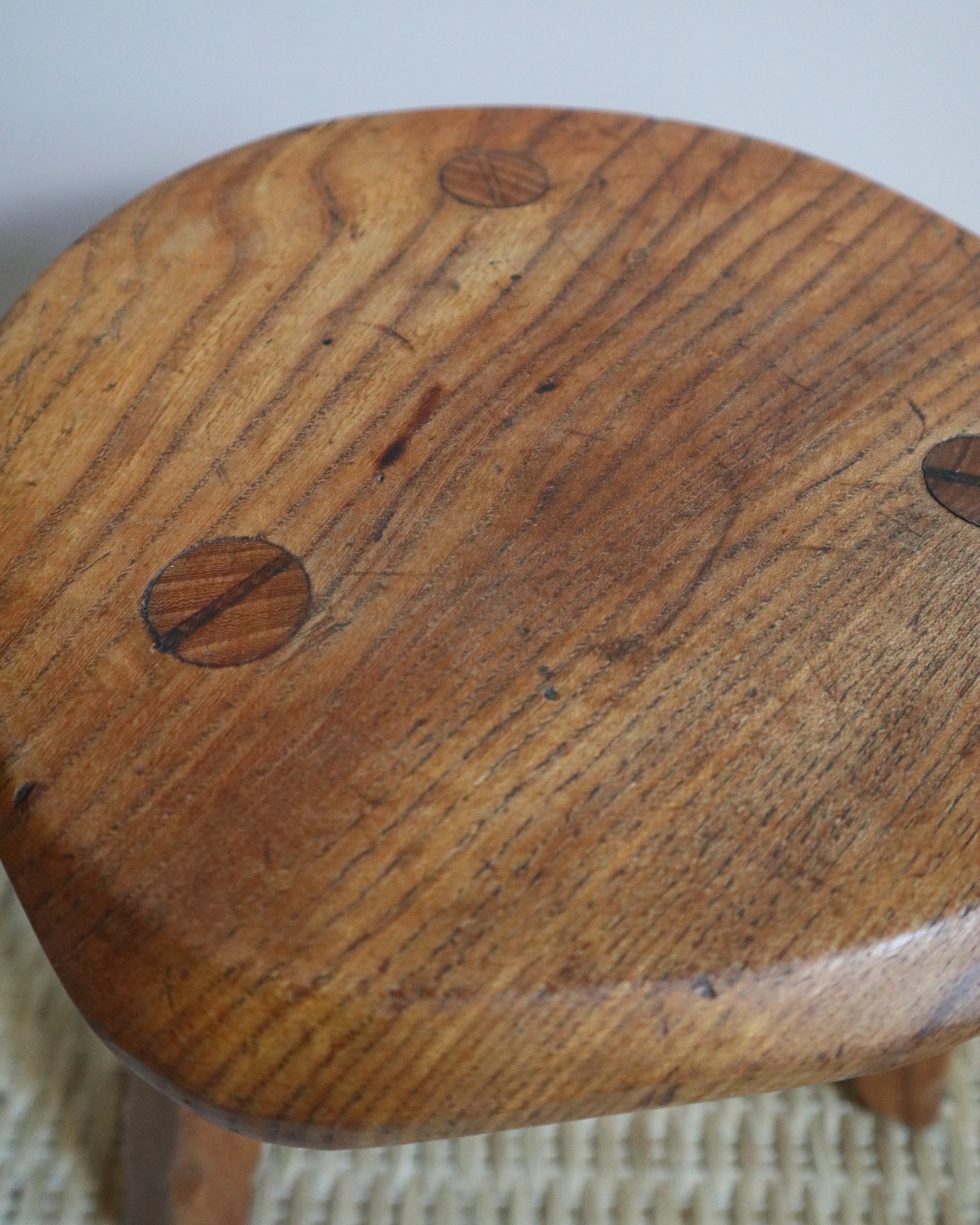 Vintage rustic handmade warm wooden tripod stool with carved legs. Stamped 'John Chapman Woodcrafts Northwood'.