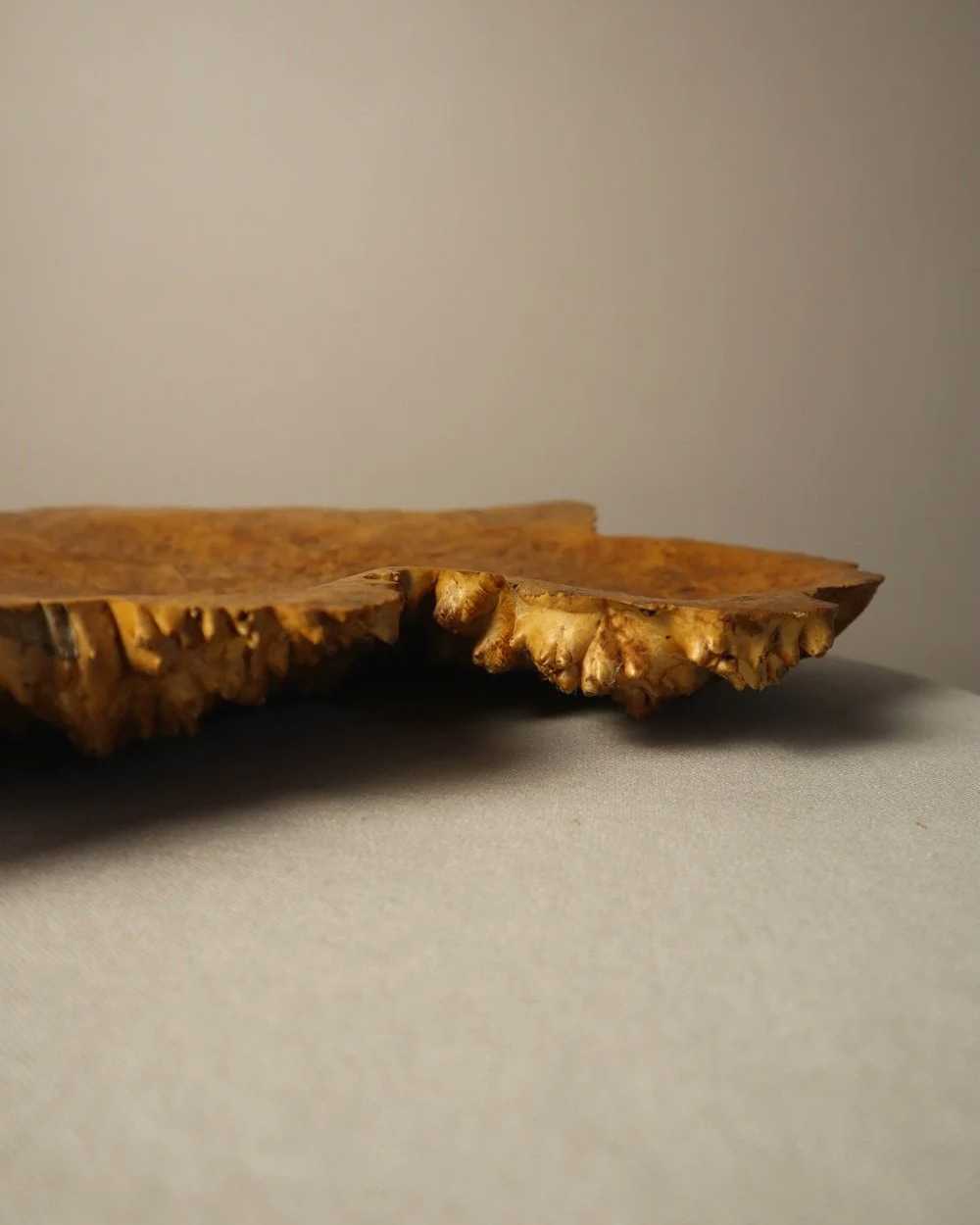 Decorative hand carved golden toned burr wood centrepiece dish with polished centre and organic naturalistic outside.