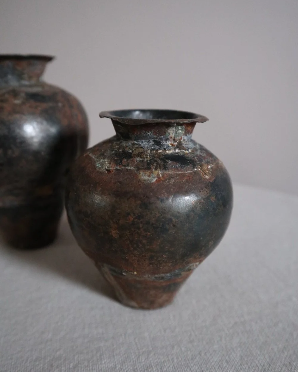 Set of two small, lightweight handmade metal vases of varying sizes.