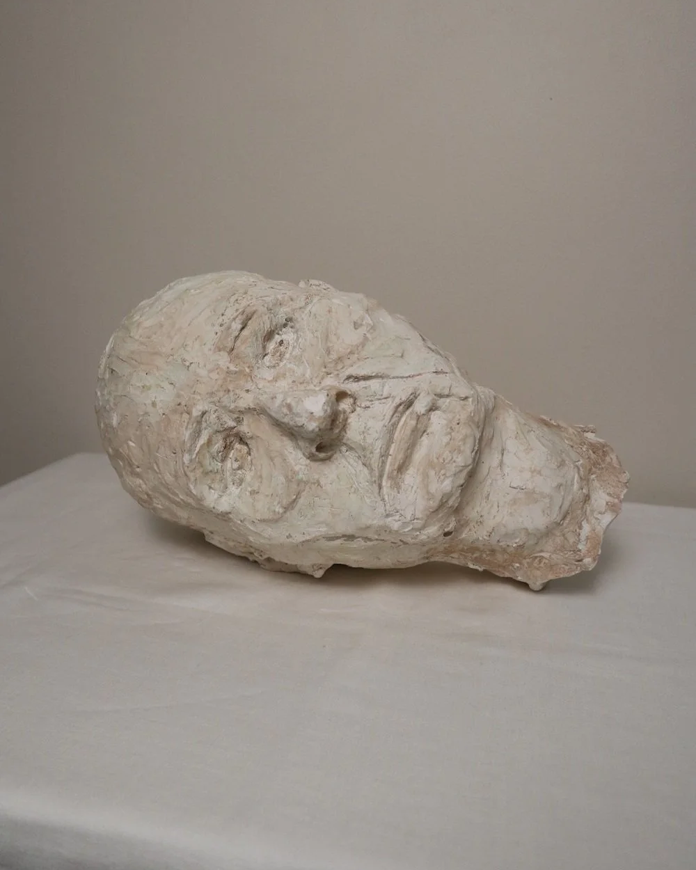 Large, heavy off white textured plaster sculpture of man's head in abstract style. Unknown age.