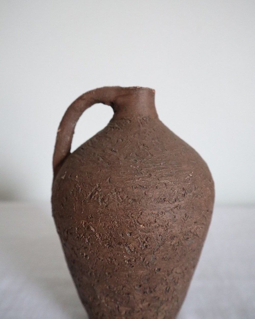 Mid century Brutalist sculptural textured brown ceramic decorative vessel or bud vase. Circa 1970s. Signed “CP”, likely the work of American potter Karl Martz for Clayburn Pottery.