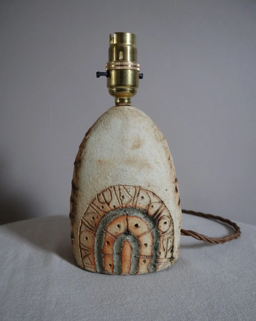 Small Brutalist stoneware table lamp by British potter Bernard Rooke. With stamped, rune-like impressions. Circa 1970s.