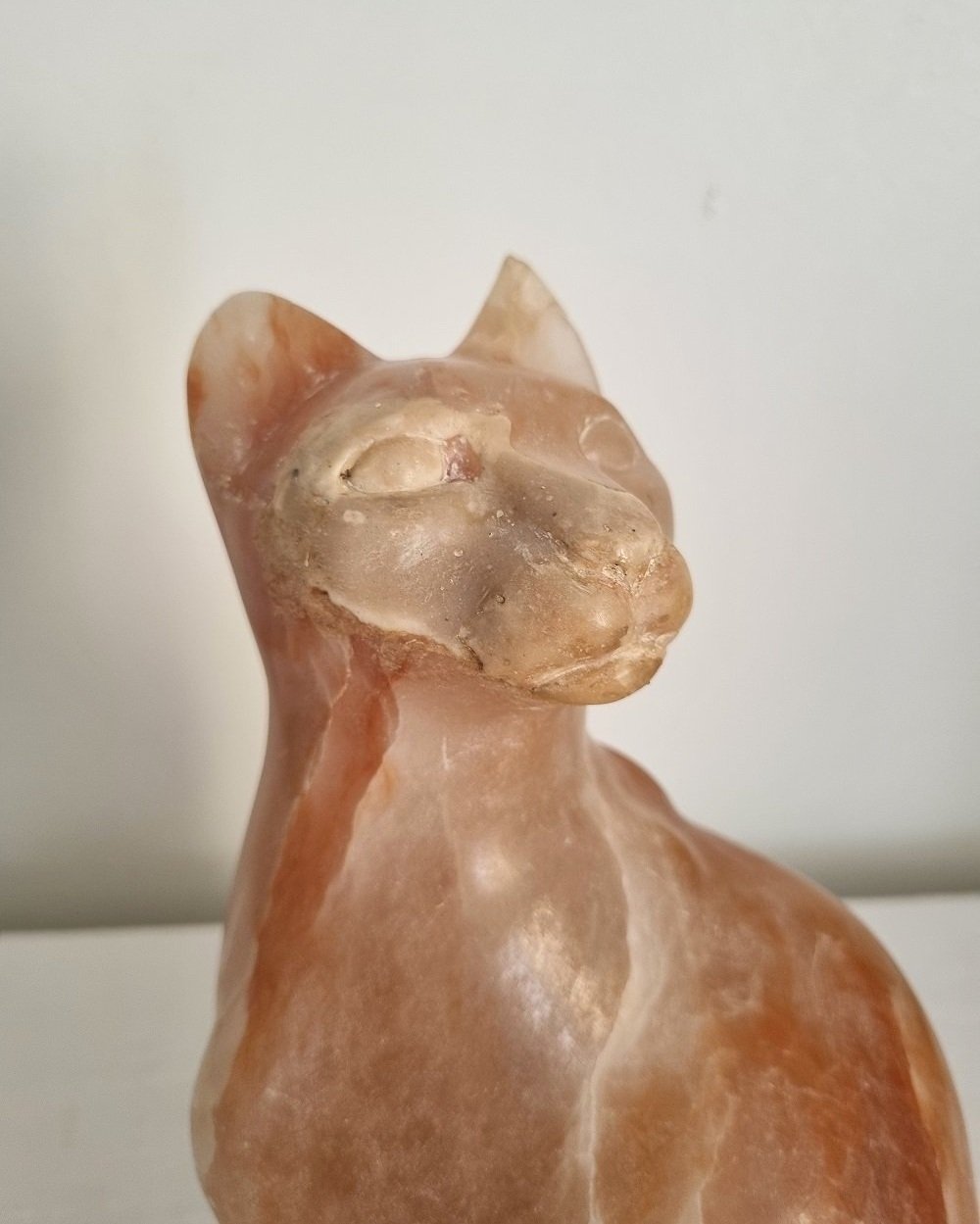 Vintage, heavy hand carved soft pink alabaster cat with striking natural grain and smooth lines.