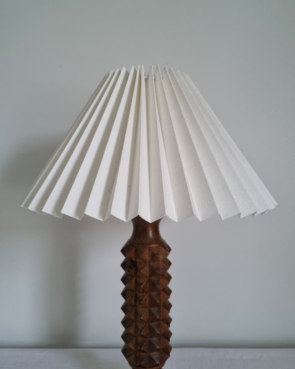 French Charles Dudouyt style carved wooden Brutalist table lamp with new, white pleated lampshade.