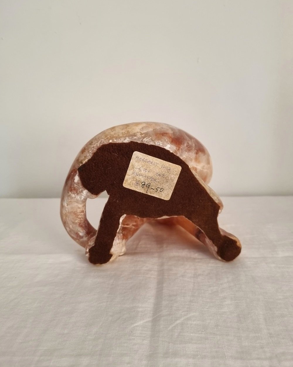 Vintage, heavy hand carved soft pink alabaster cat with striking natural grain and smooth lines.