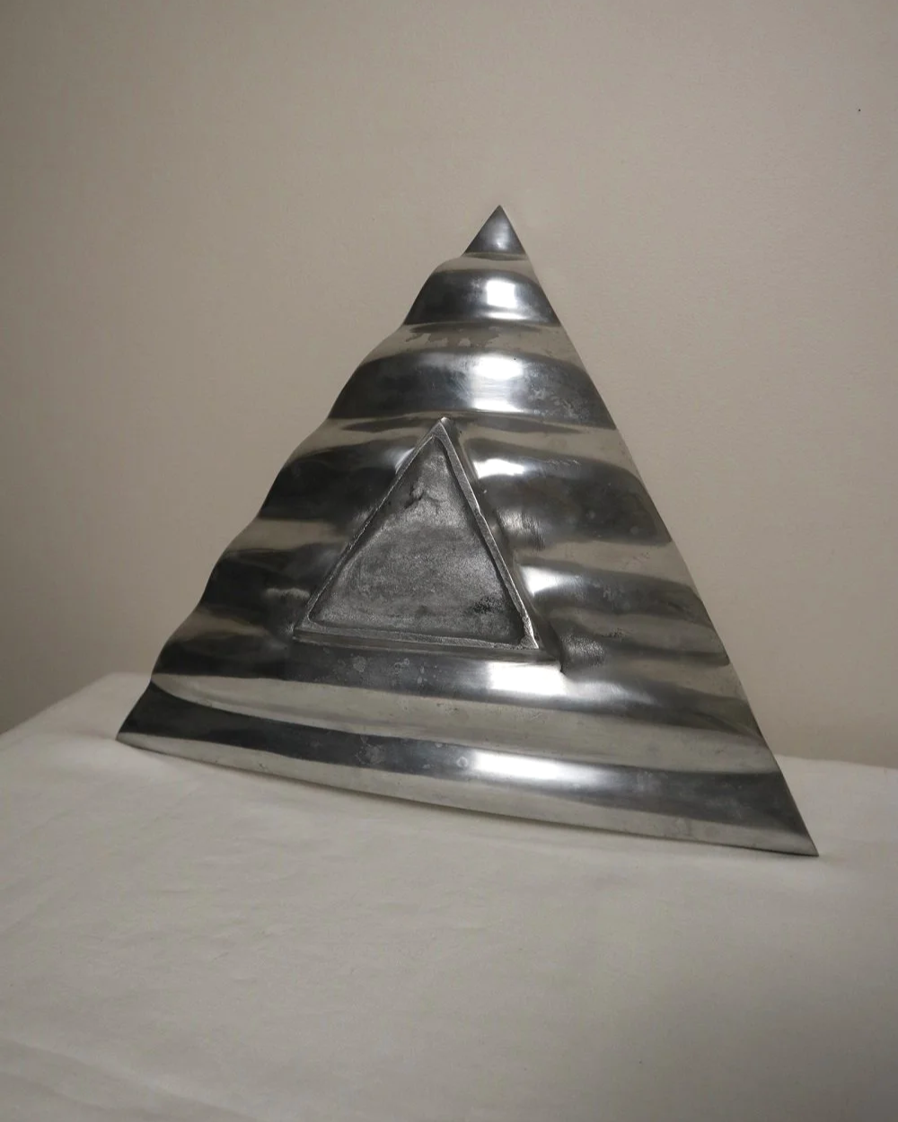 Large mid century, shiny cast aluminium triangular display dish with wavy edge.