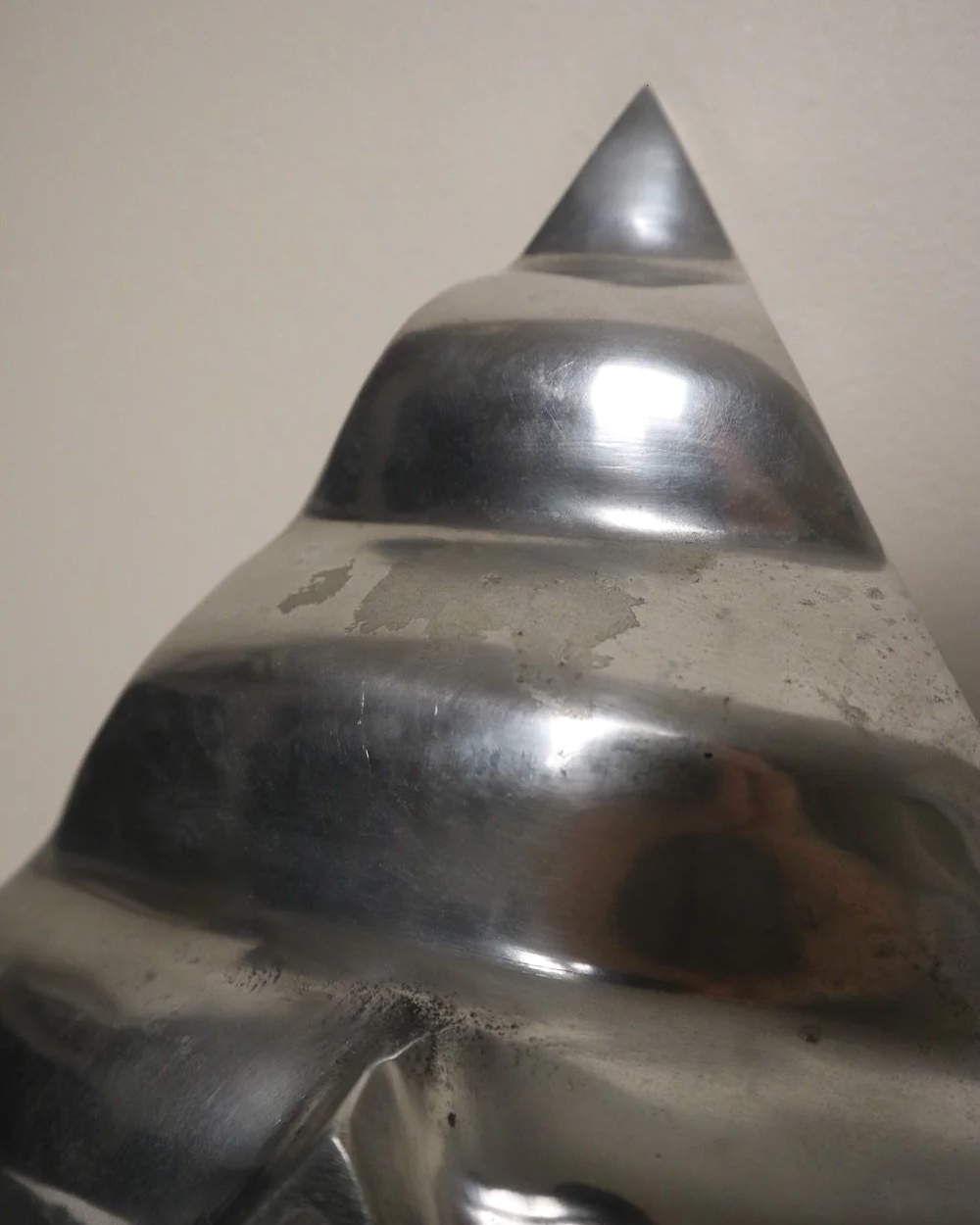 Large mid century, shiny cast aluminium triangular display dish with wavy edge.