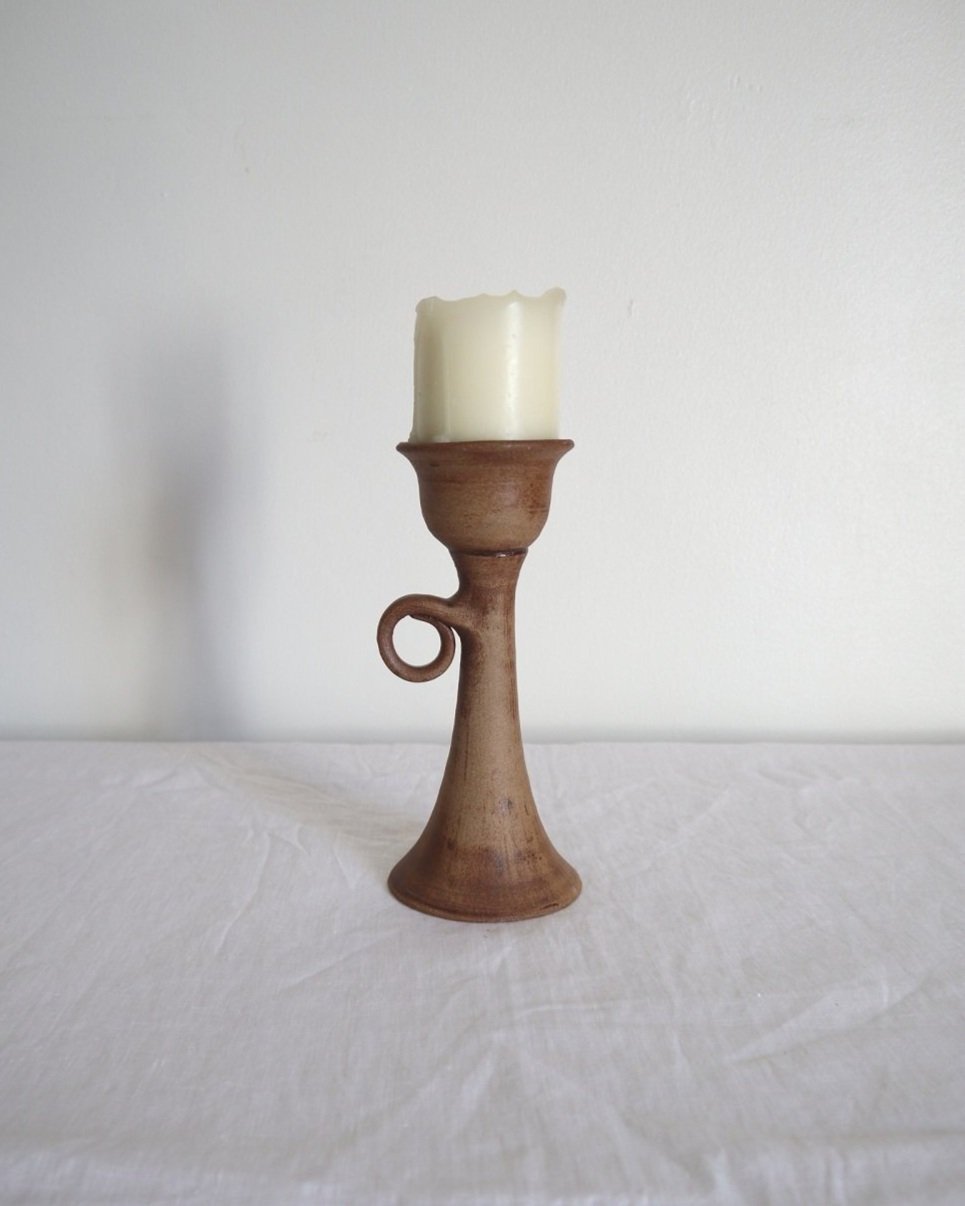 Rustic handmade studio pottery sculptural candleholder with curled circular handle.