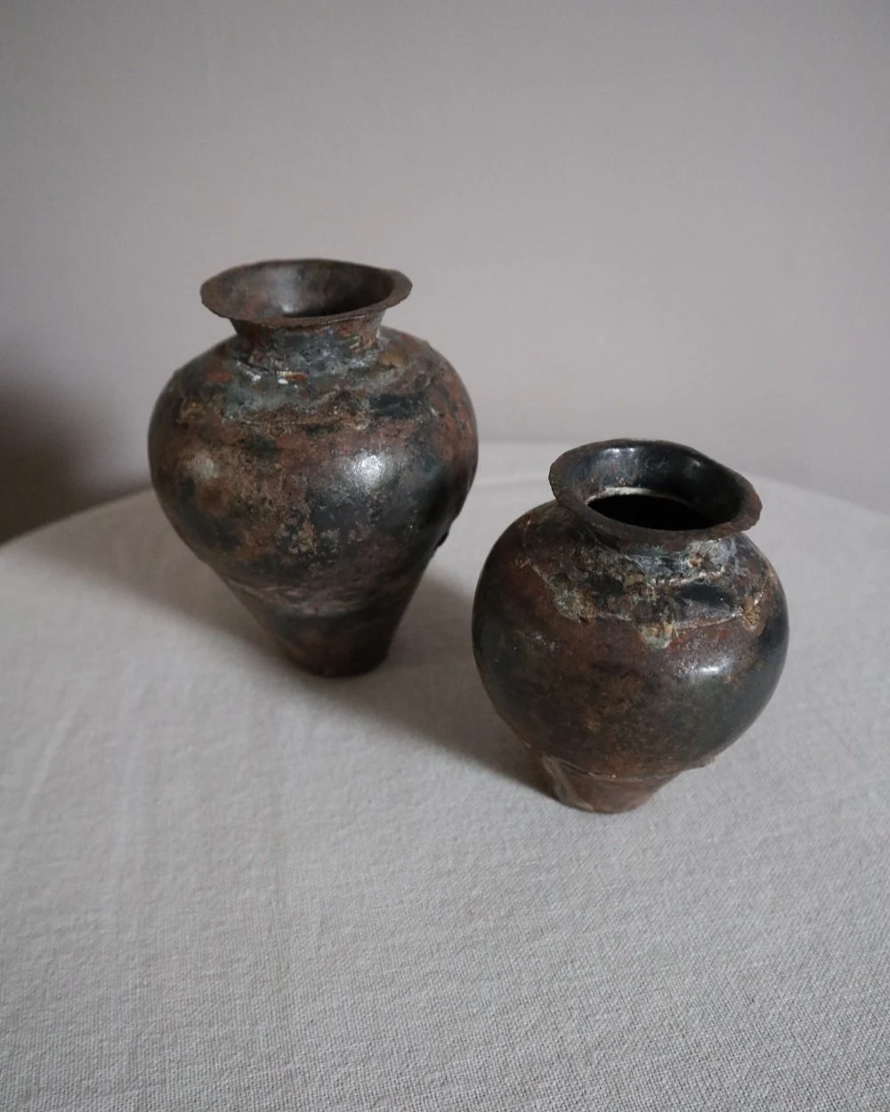 Set of two small, lightweight handmade metal vases of varying sizes.