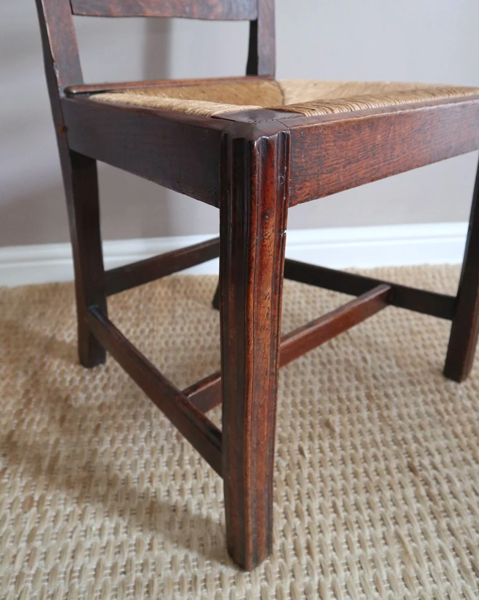 Pair of sculptural rustic oak ladder back dining chairs with rush seats, circa 1930s.
