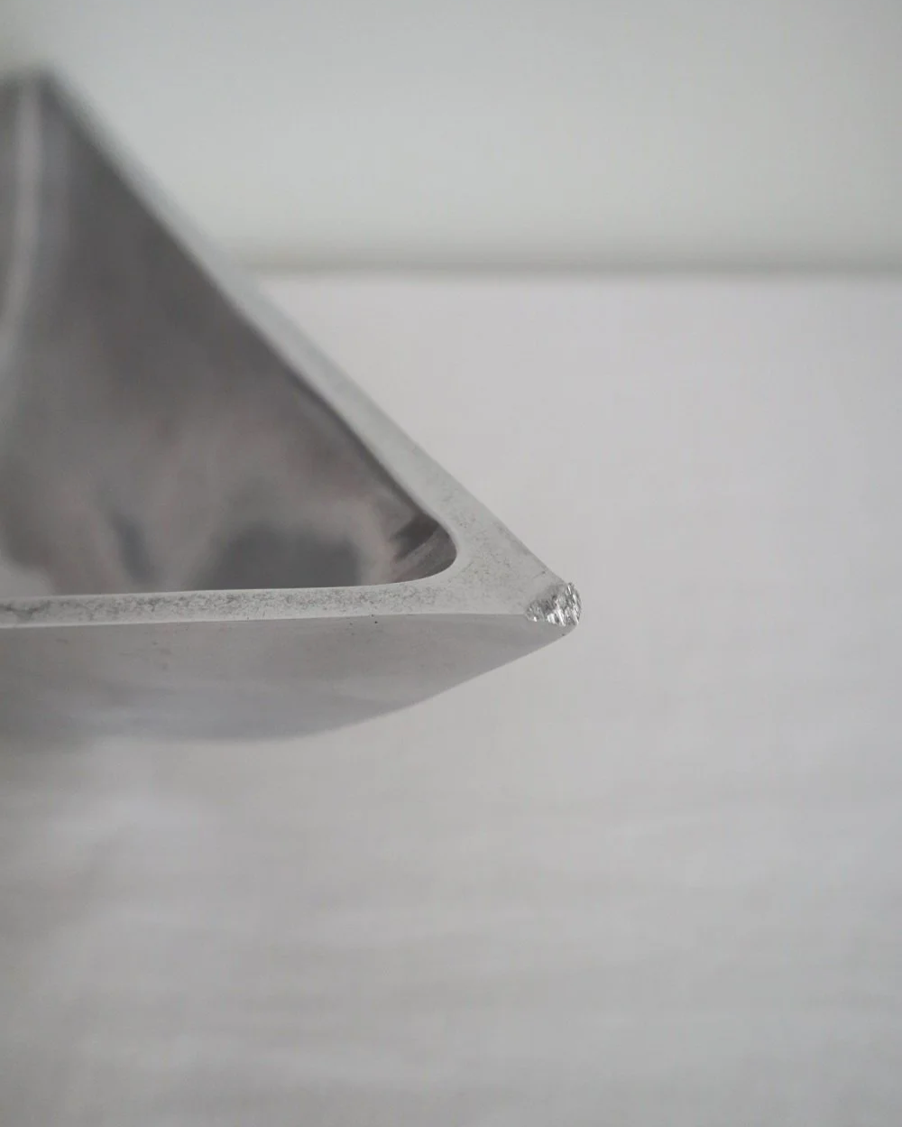 Solid shiny aluminium triangular Modernist style dish.