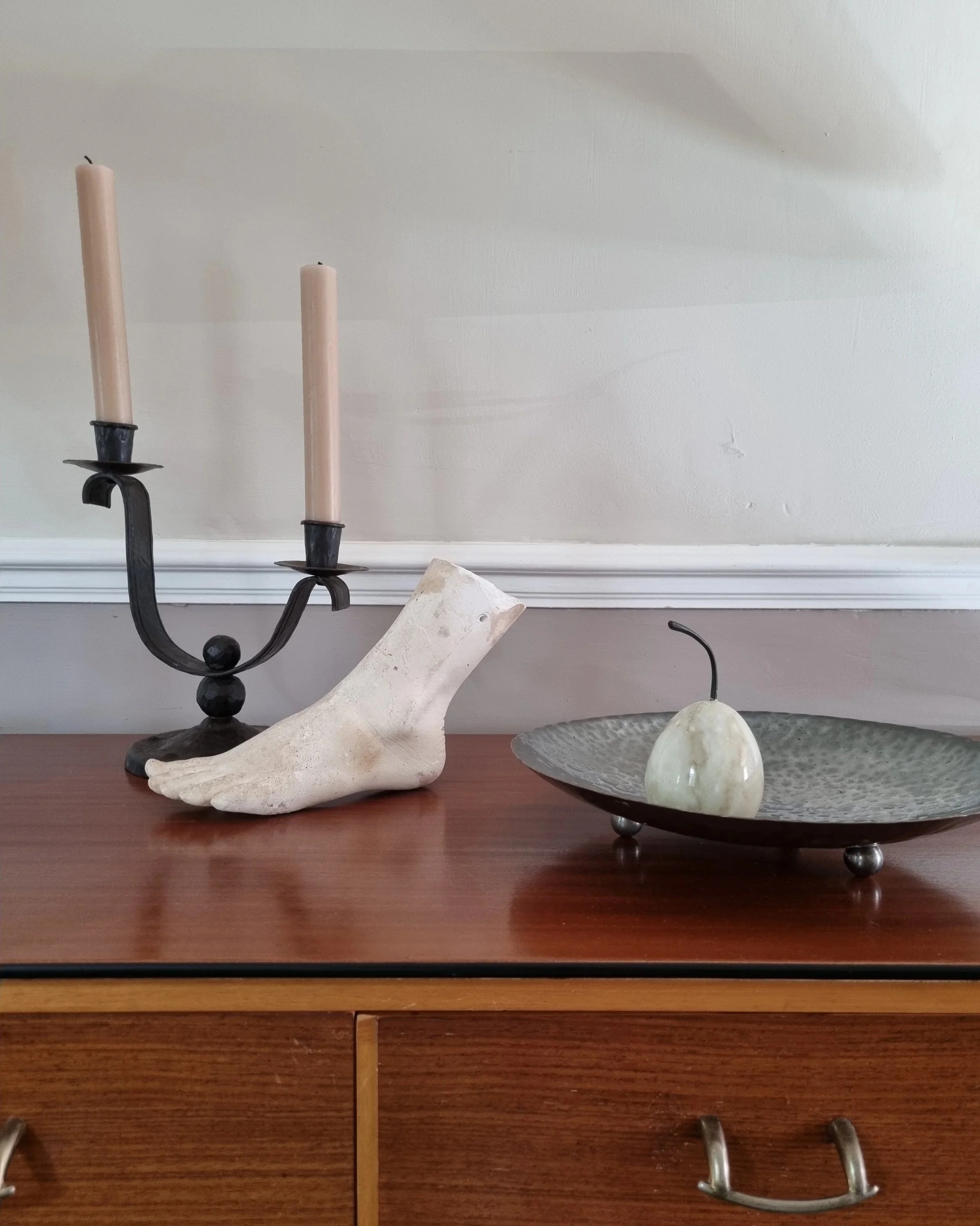 Heavy Brutalist style forged iron candleholder with off set double arms and circular base.