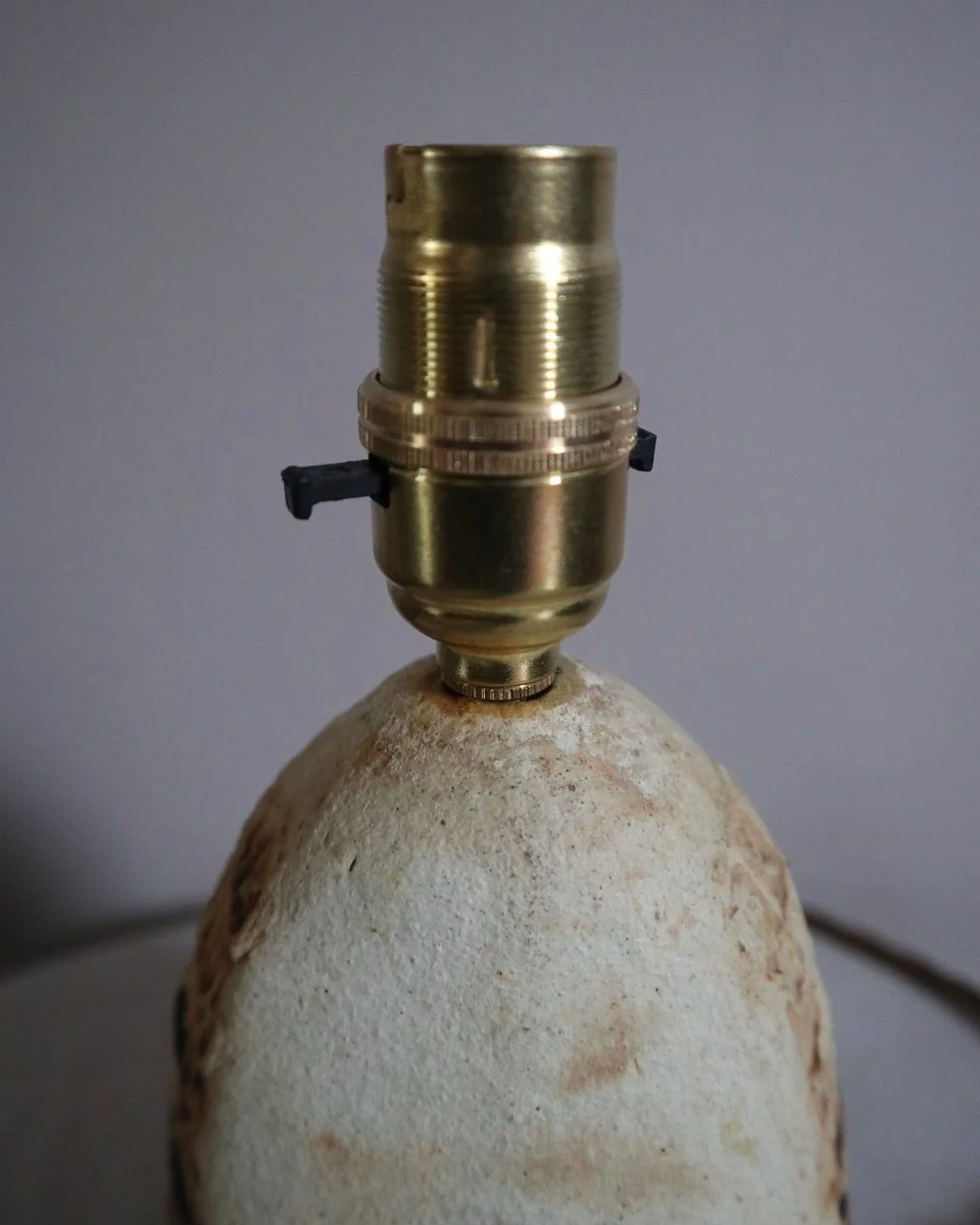 Small Brutalist stoneware table lamp by British potter Bernard Rooke. With stamped, rune-like impressions. Circa 1970s.