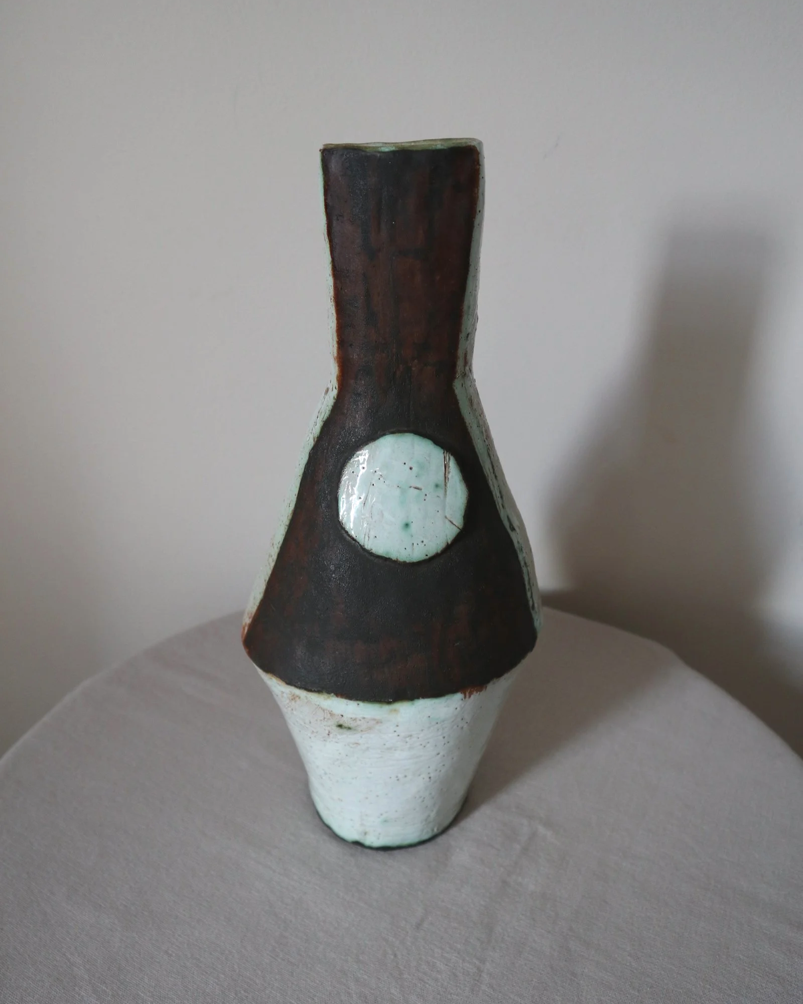 Vintage hand-built ceramic Brutalist art vase, featuring an abstract, asymmetrical design with textured white, dark brown, and subtle green glazes.