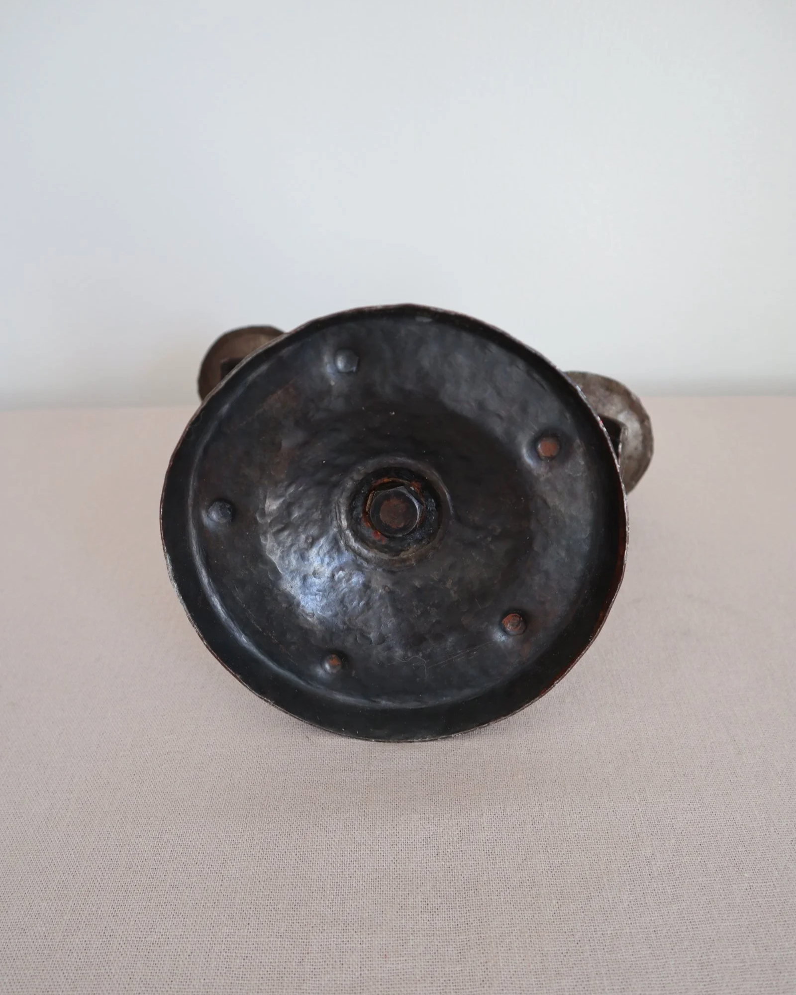 Heavy Brutalist style forged iron candleholder with off set double arms and circular base.