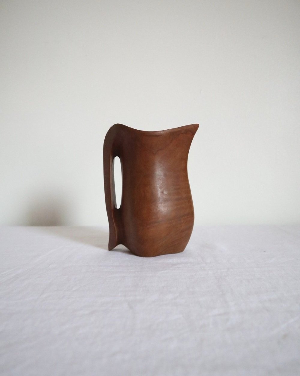 Small sculptural hand carved dark olivewood monoxyl pitcher, circa 1960/70s. In the manner of Alexandre Noll. Unsigned.