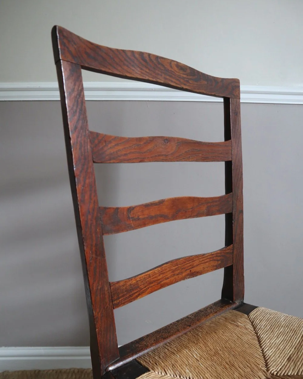 Pair of sculptural rustic oak ladder back dining chairs with rush seats, circa 1930s.