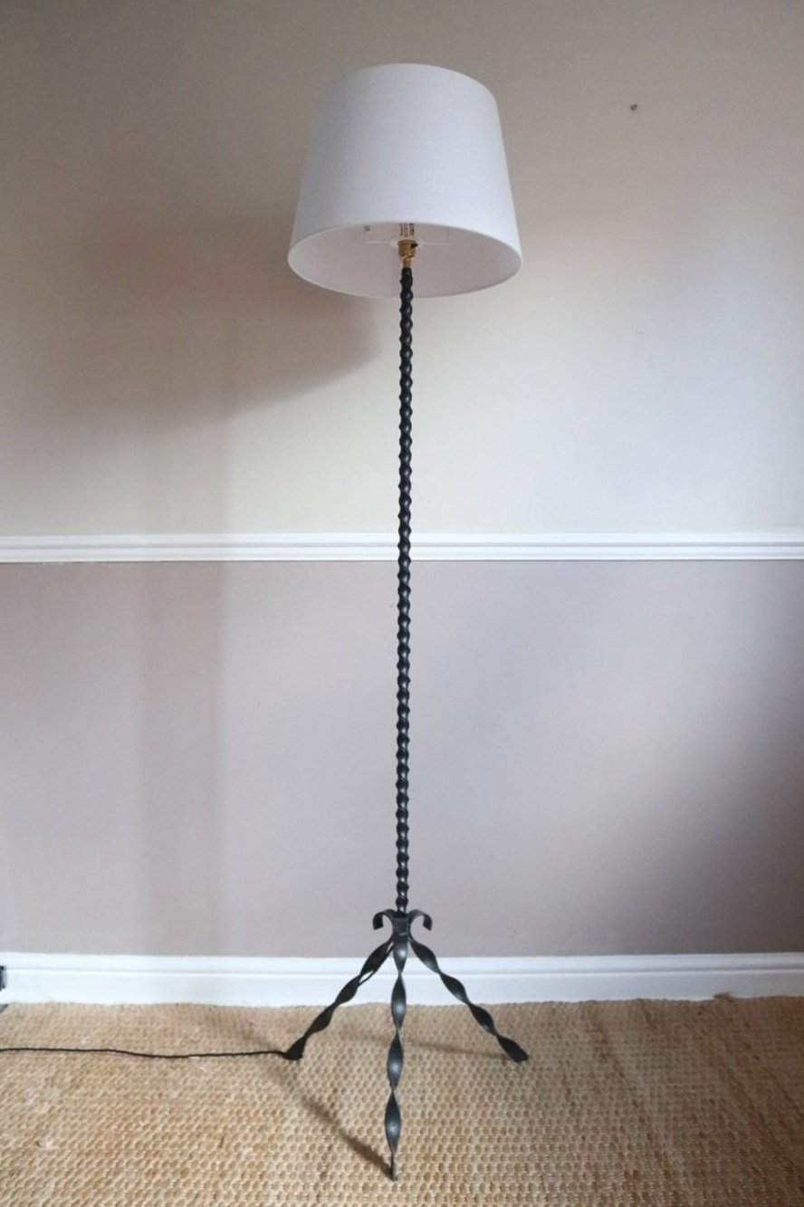 French wrought iron floor lamp with twisted corkscrew column and tripod base. Circa 1950s.