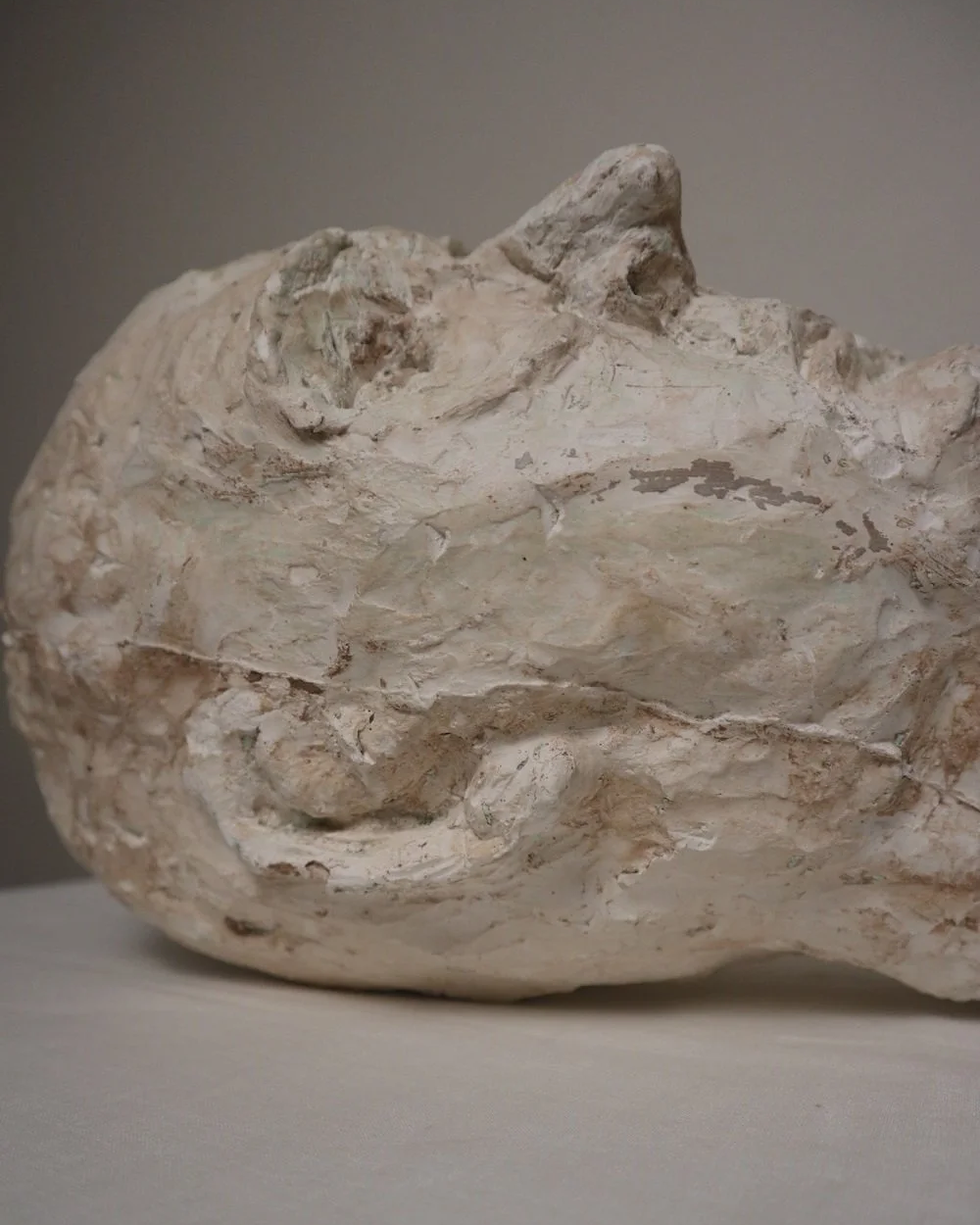 Large, heavy off white textured plaster sculpture of man's head in abstract style. Unknown age.