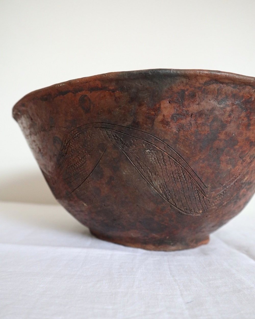 Large Nigerian Abuja pottery handmade organic bowl with scraffito markings. With brown mottled colouring and etched abstract details to inside and out.