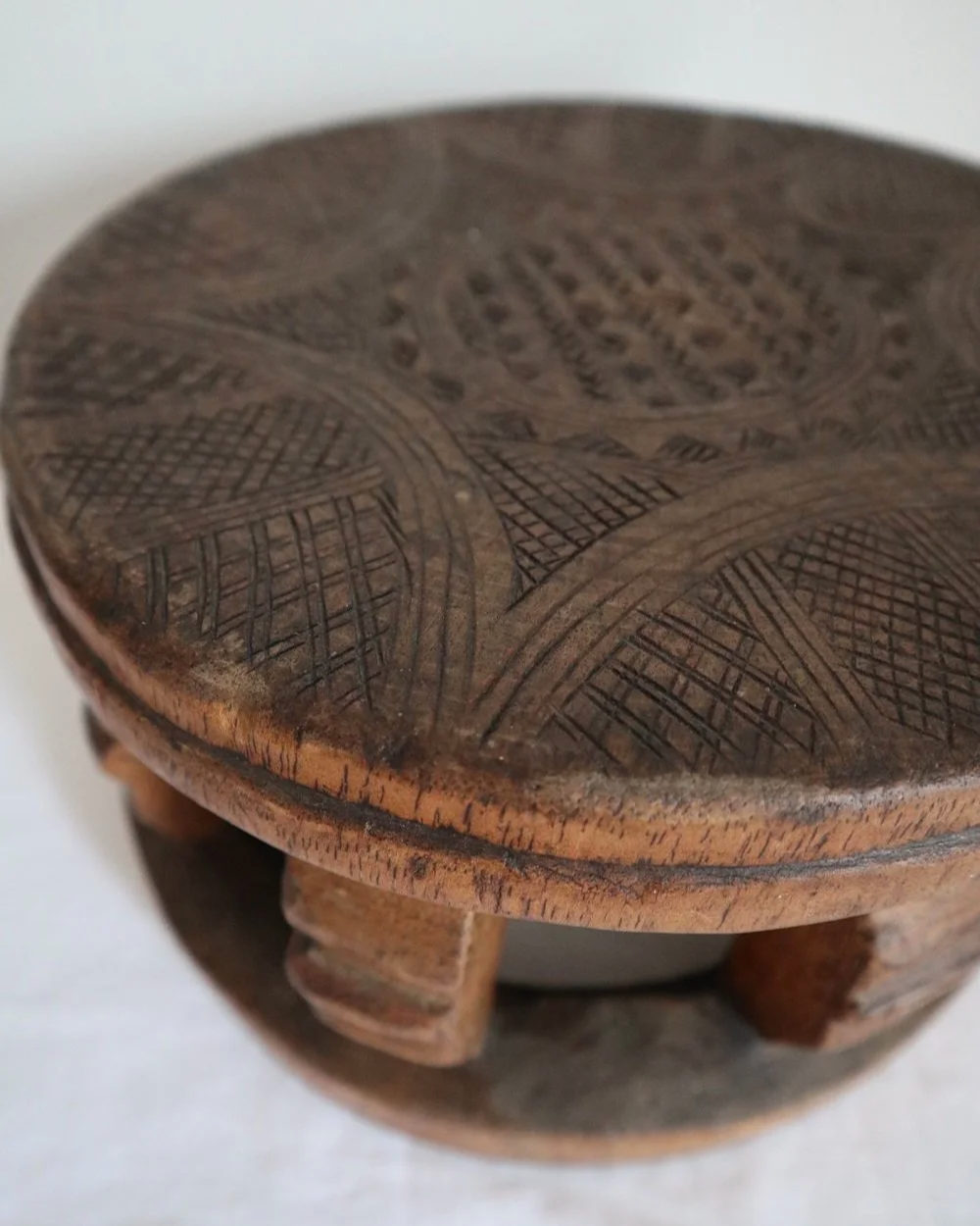 Vintage Nigerian small circular low stool carved from one piece of wood with decorative etchings to surface.
