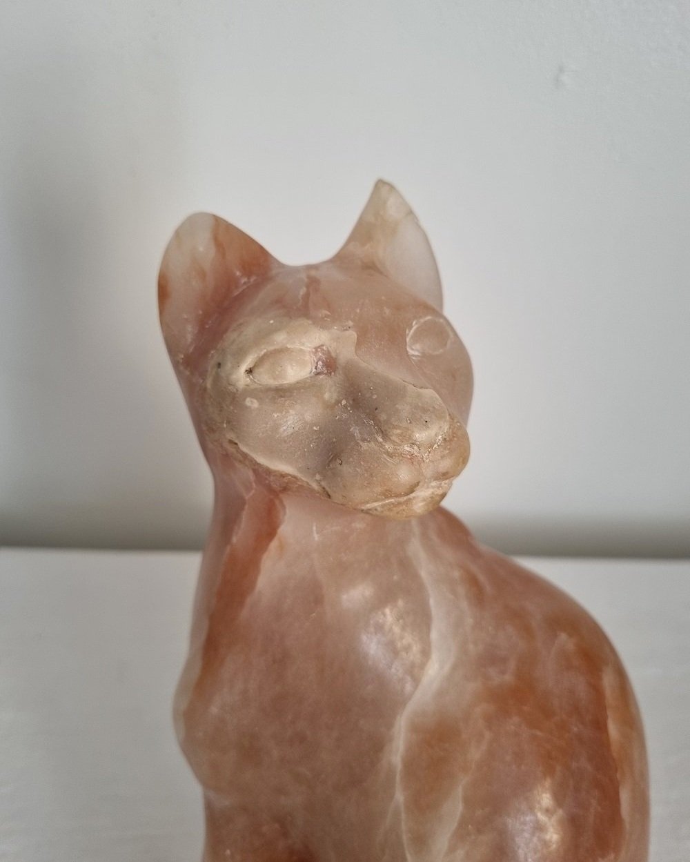 Vintage, heavy hand carved soft pink alabaster cat with striking natural grain and smooth lines.