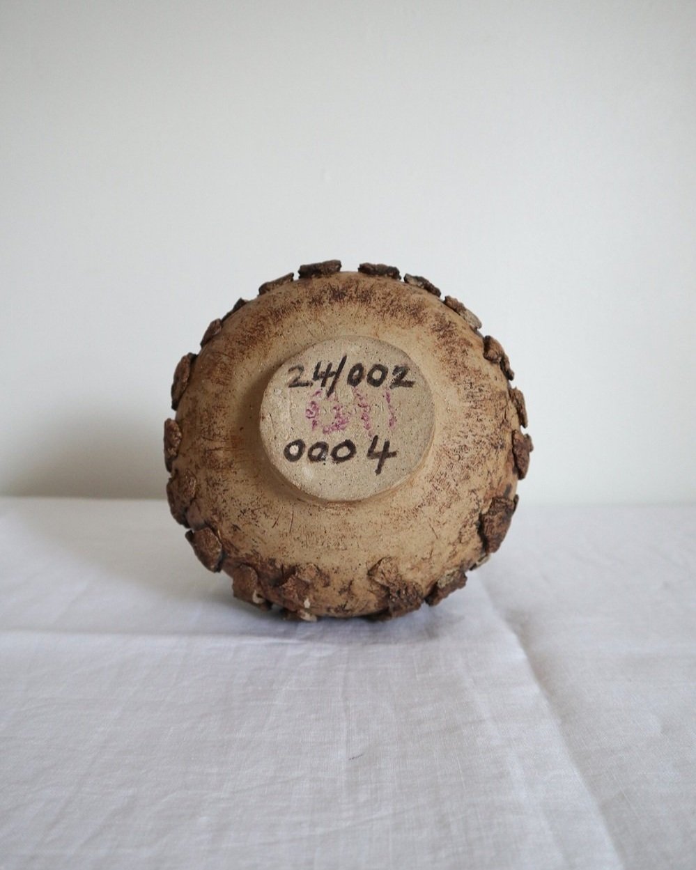 Studio pottery brown ceramic decorative vase with textured, tree bark effect decorations and a tapered neck. Age unknown.
