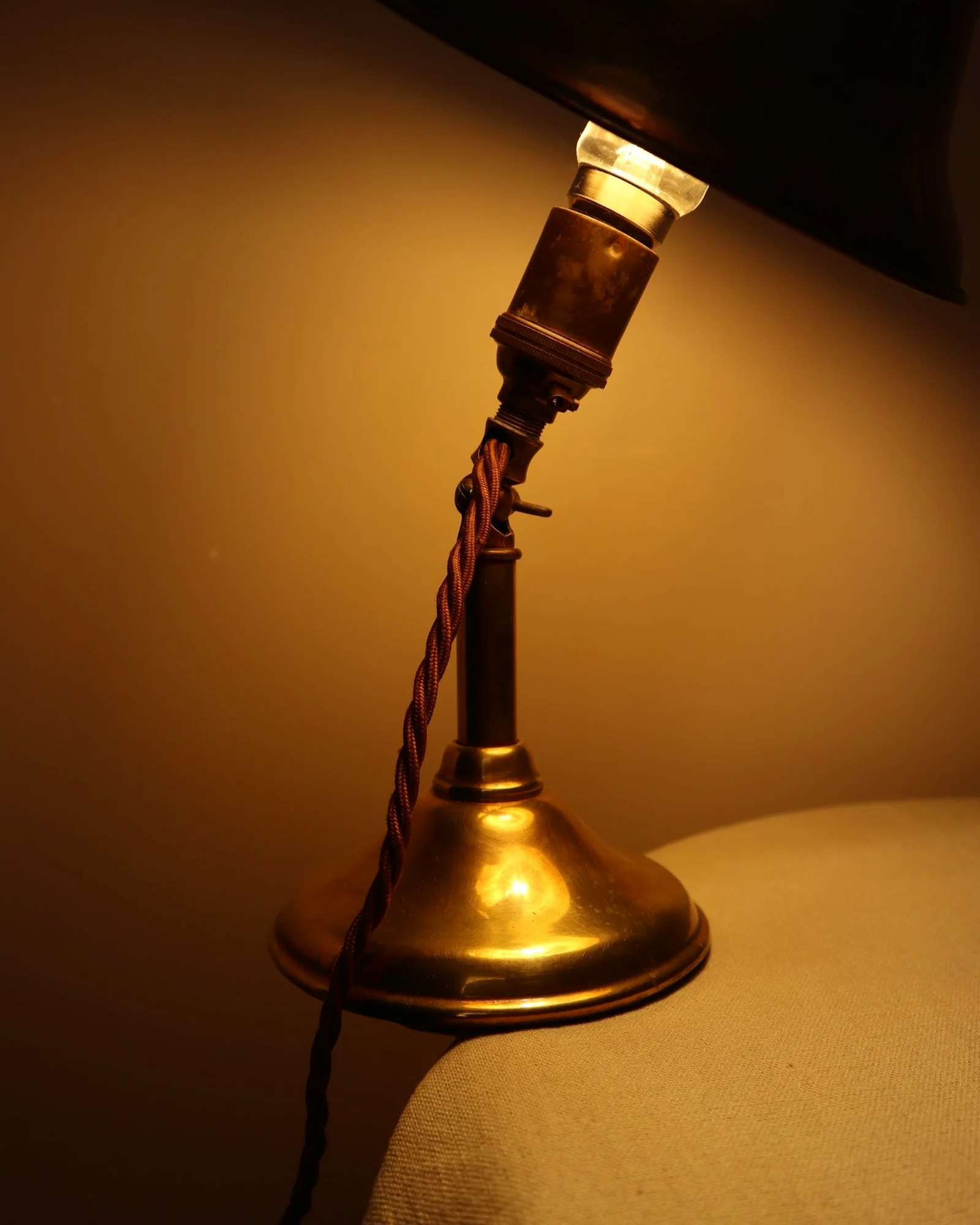 Small, vintage adjustable brass worker's desk lamp. Can be freestanding or attached to the edge of a workbench etc with clamp.