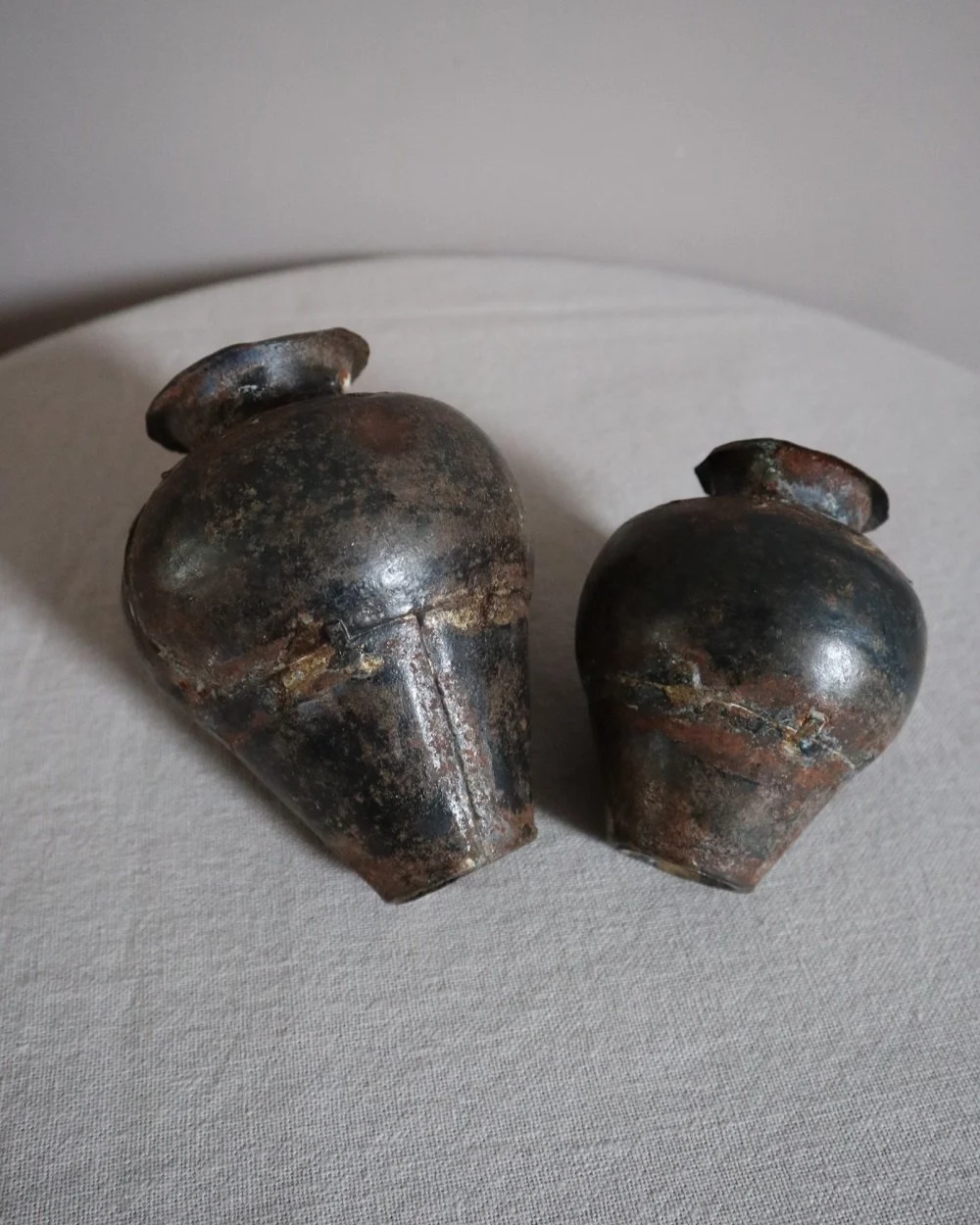 Set of two small, lightweight handmade metal vases of varying sizes.