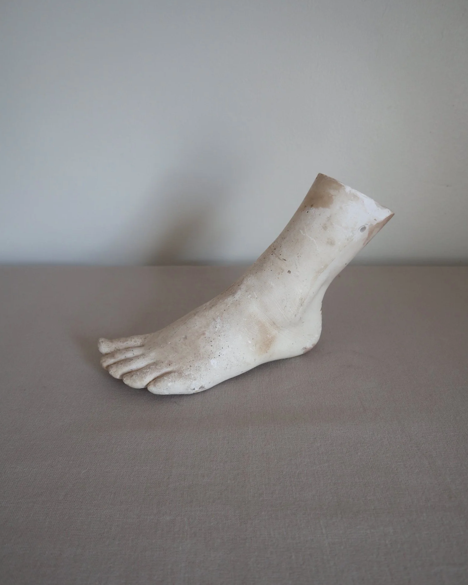 Classical-style decorative plaster foot sculpture, likely used as an anatomical or art studio study model.