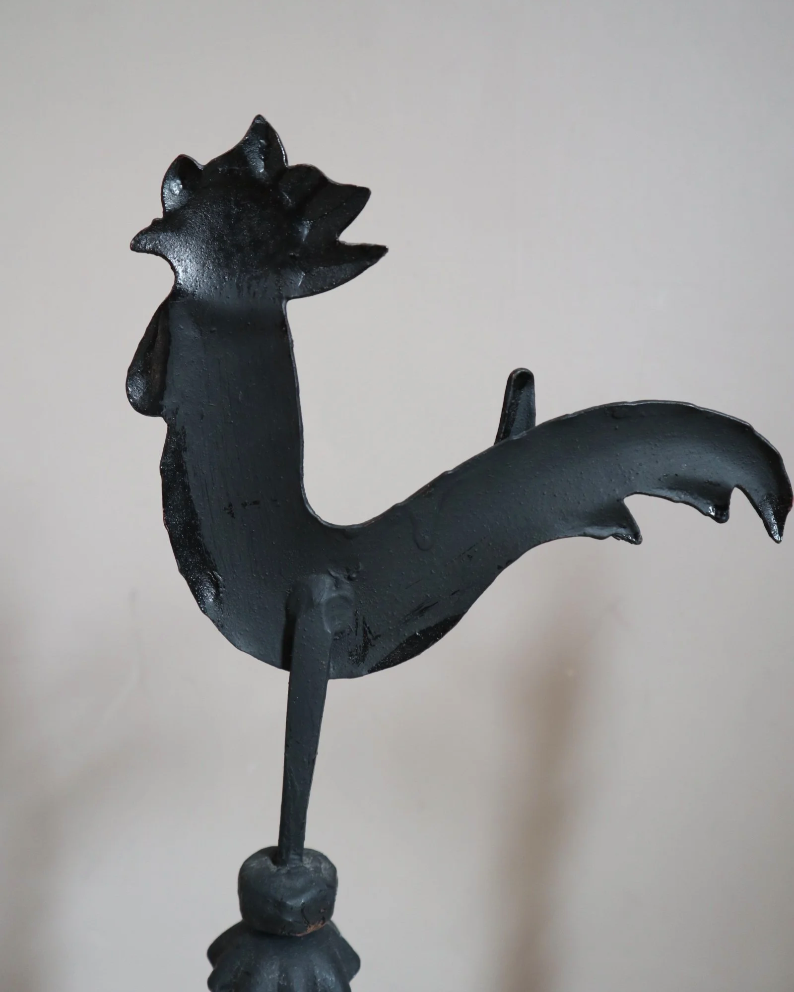 Pair of black wrought-iron andirons or firedogs featuring stylized rooster finials, circa mid-20th century.